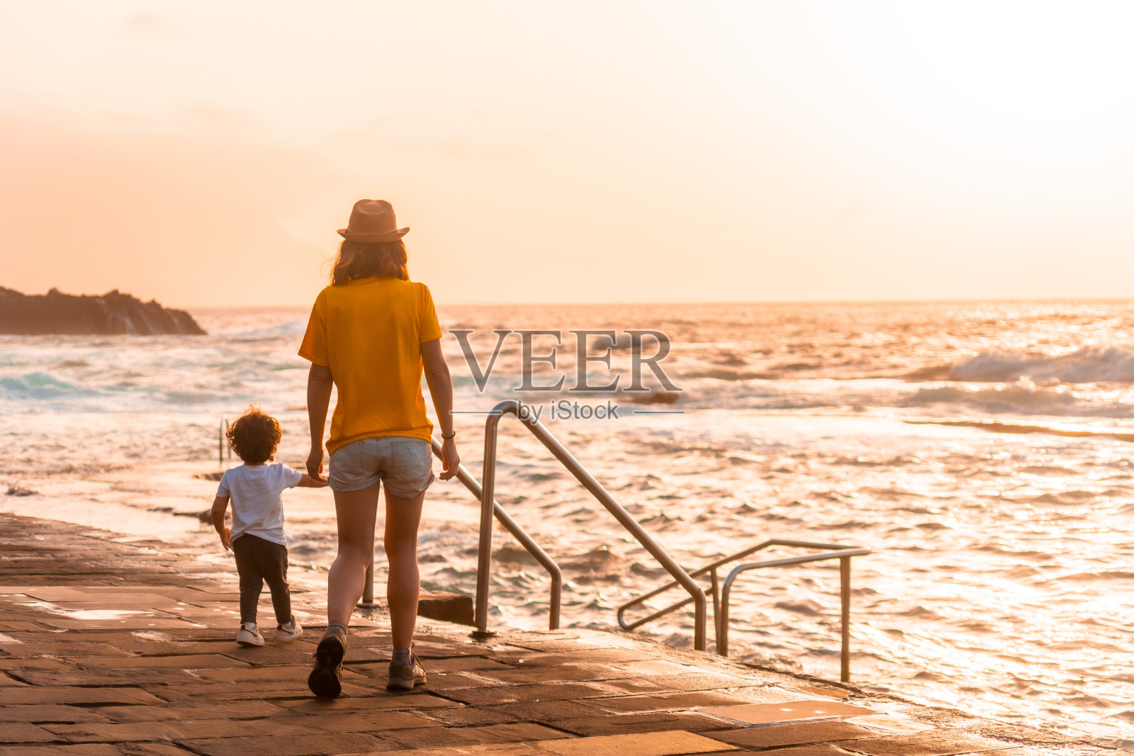 加那利群岛El Hierro en La Frontera岛上的La Maceta岩石池，日落时分，母亲带着儿子照片摄影图片