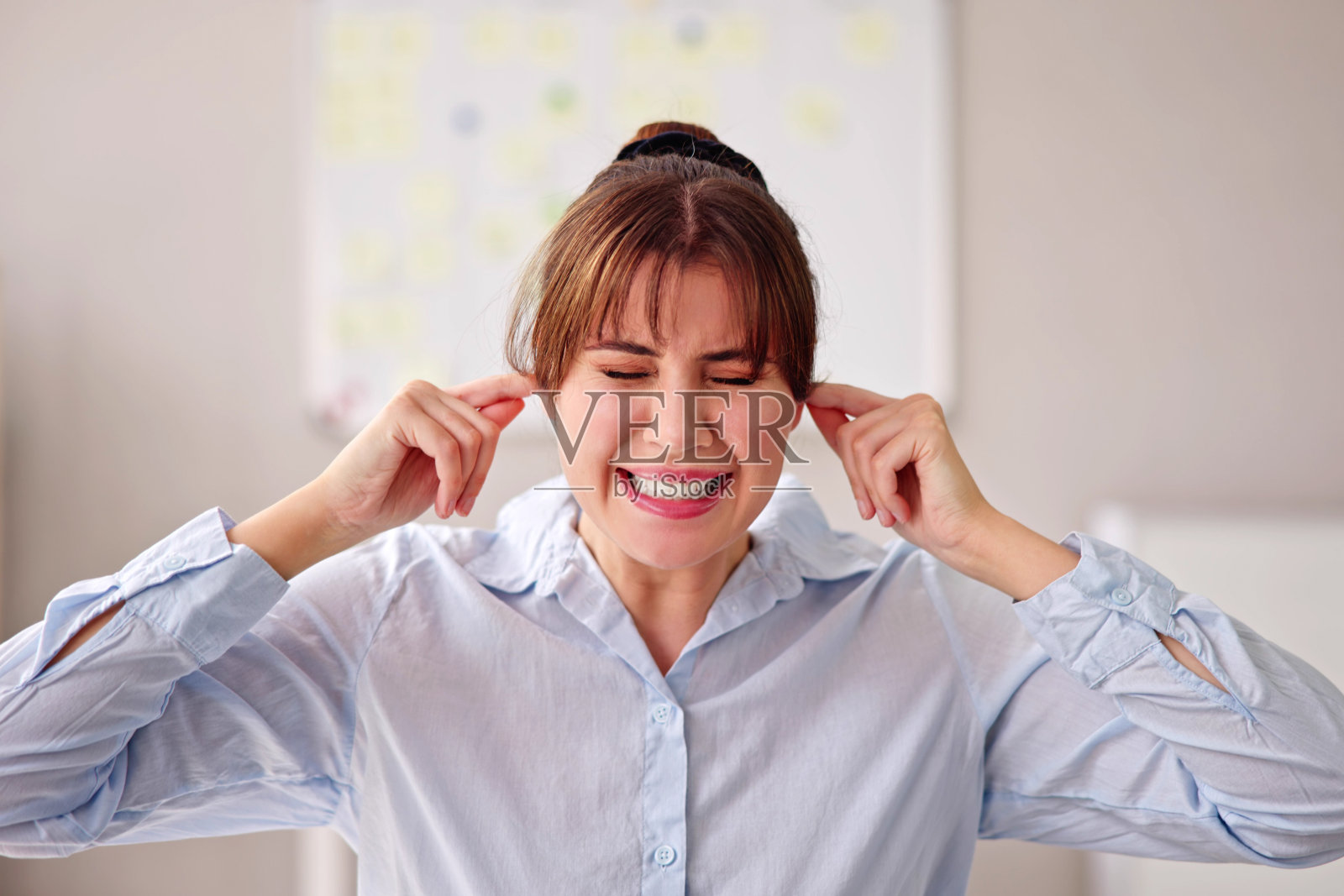 女人用手指捂住耳朵照片摄影图片