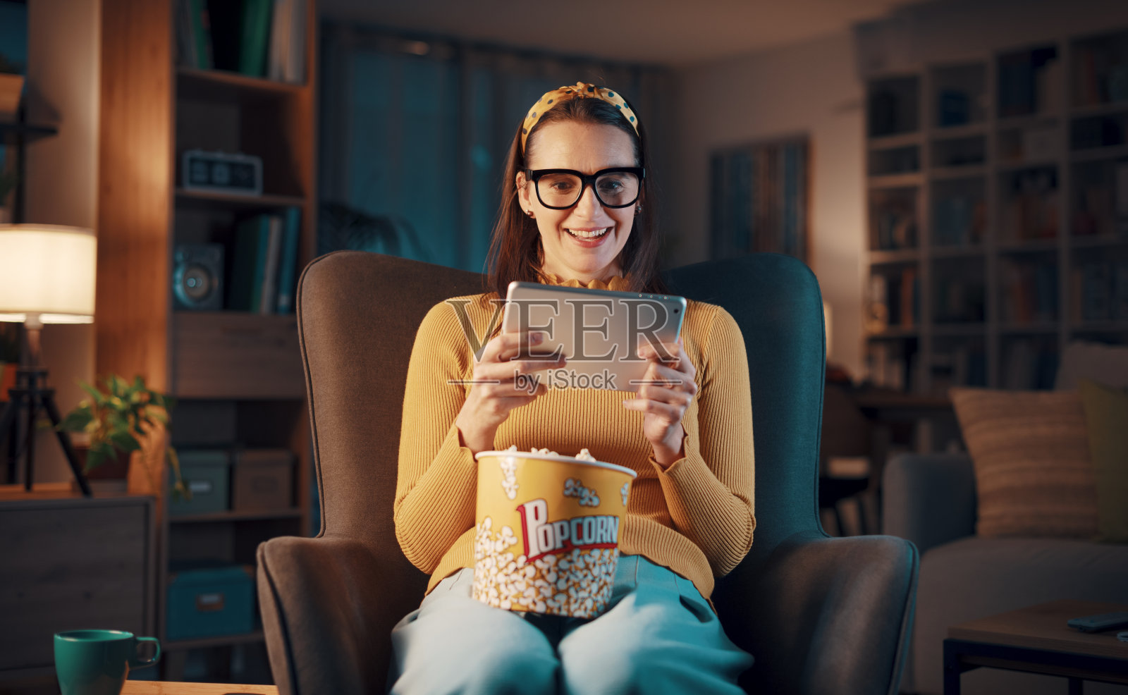 在平板电脑上看电影的快乐女人照片摄影图片