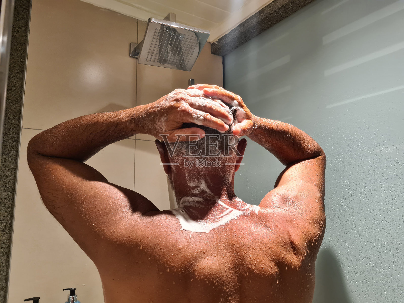 男人洗澡时用洗发水洗头照片摄影图片