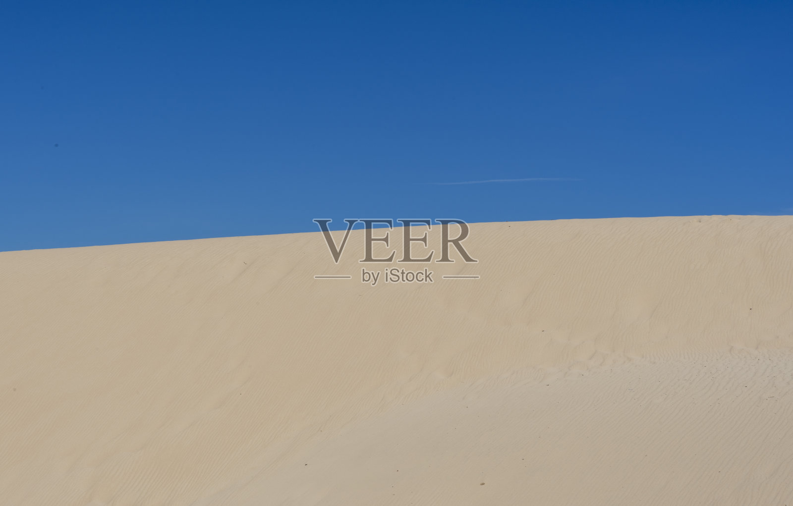 这是西班牙塔里法海滩上以蓝天为背景的沙丘照片摄影图片