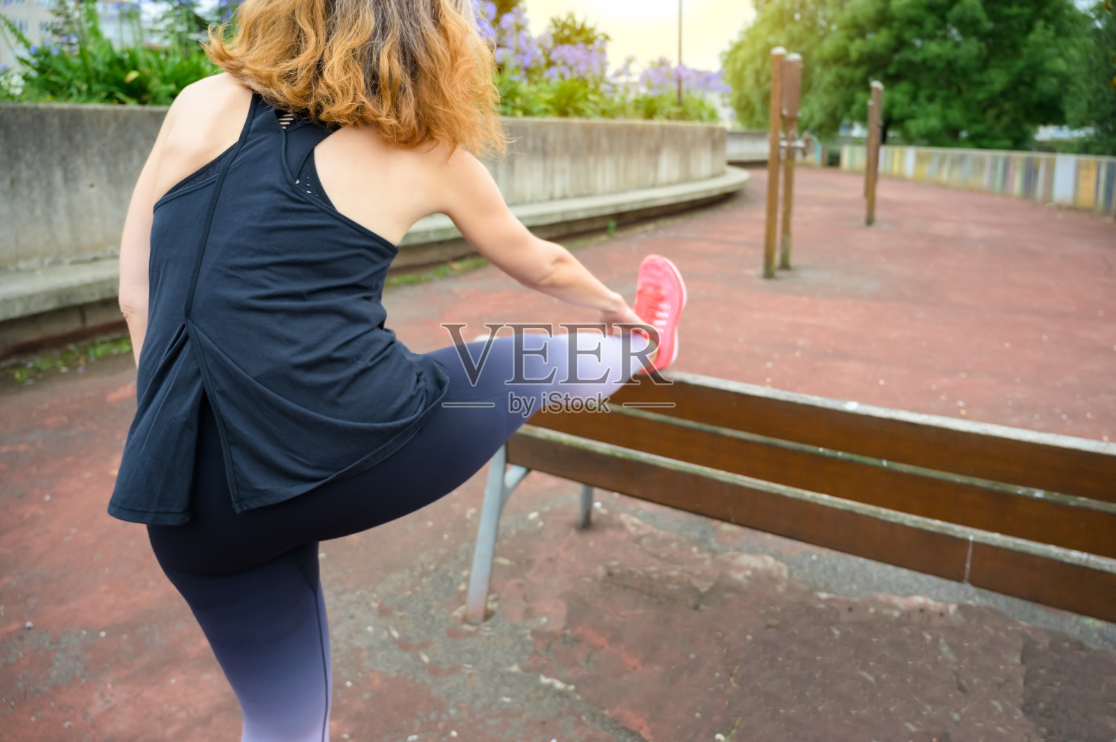 运动后穿着运动服的妇女伸展身体照片摄影图片