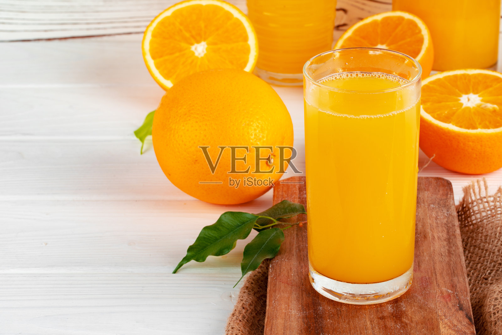 一杯橙汁和桌上切好的橙子照片摄影图片