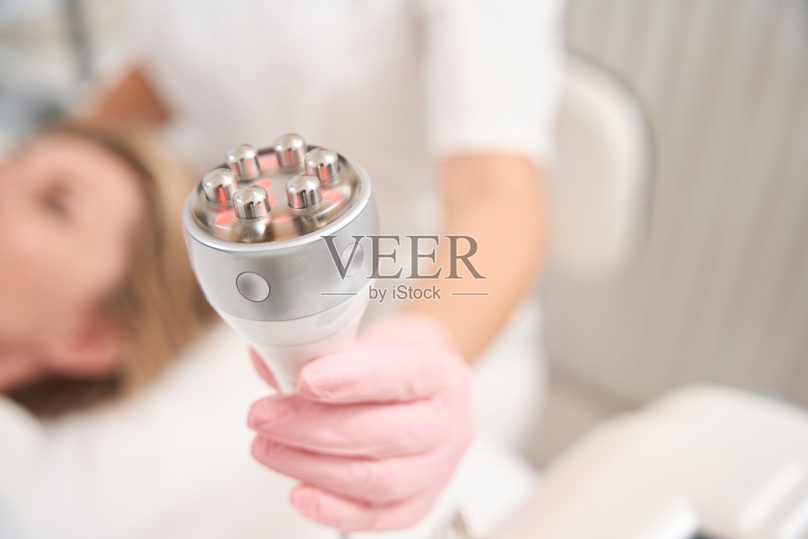 专业的美容师手里拿着一个放射提容装置照片摄影图片
