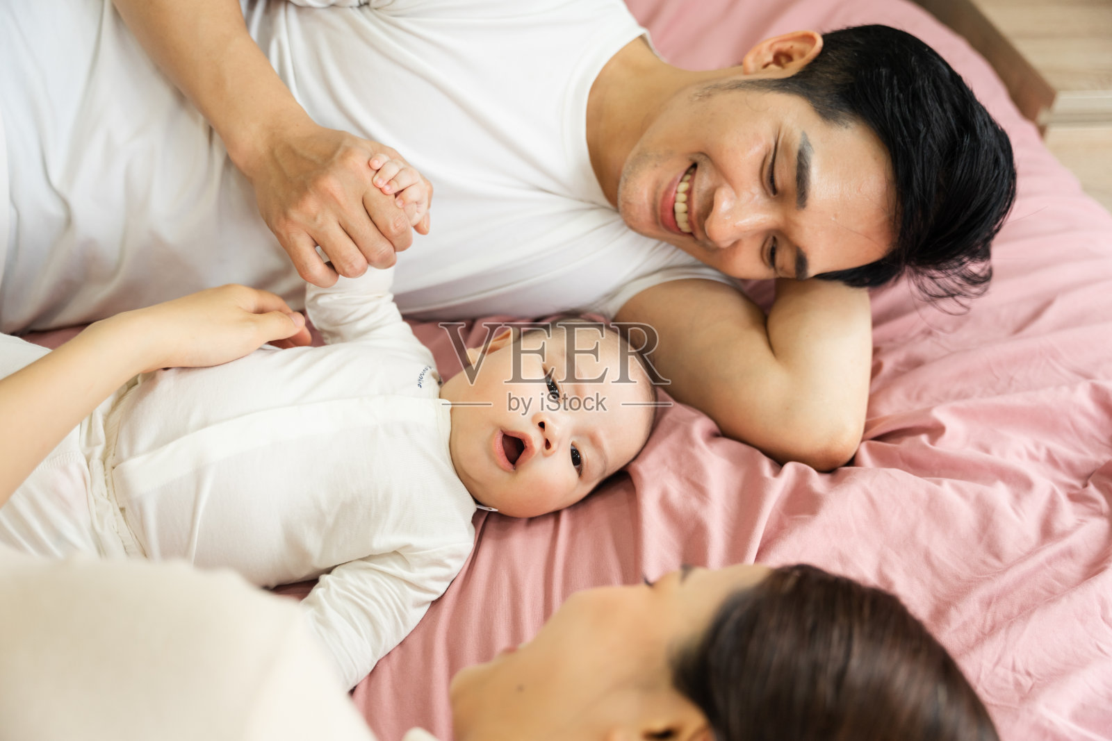 婴儿躺在床上的亚洲家庭形象照片摄影图片