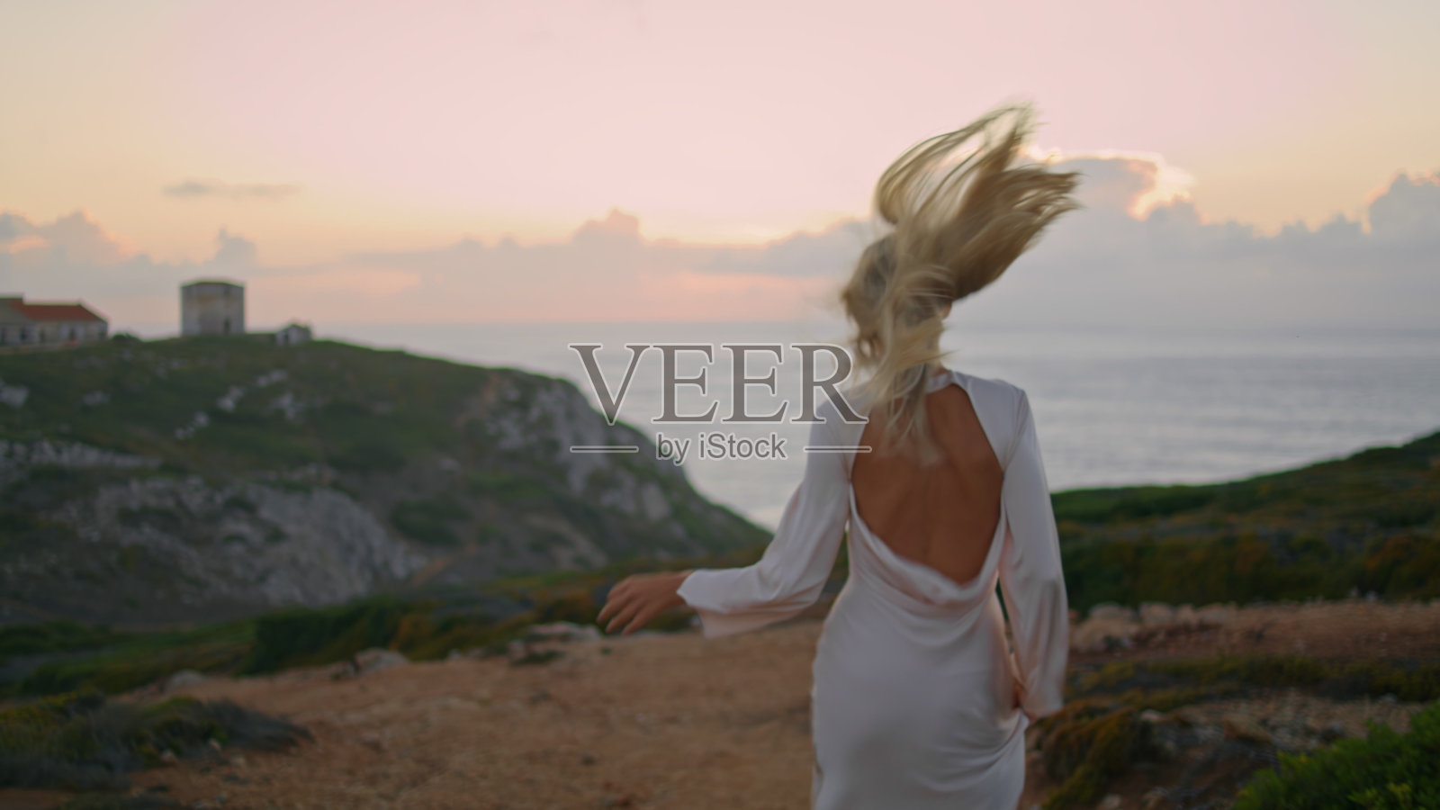 金发女子移动城堡海岸的后景。快乐的女孩跑空山谷照片摄影图片