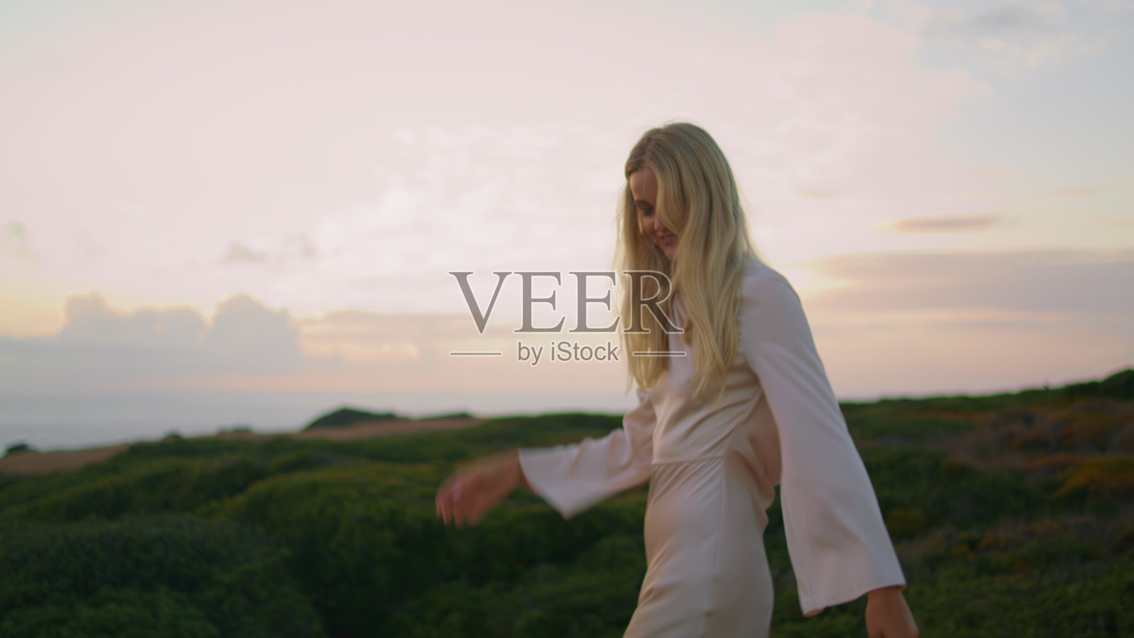 宁静的模特在平静的自然中微笑着。女孩在日落海岸摆姿势照片摄影图片