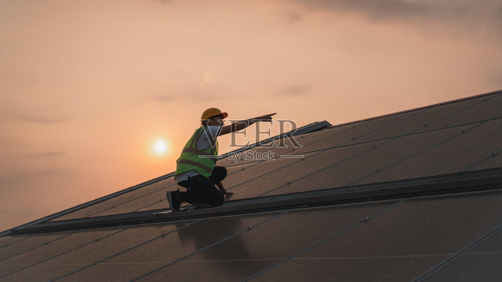 维修工程师检查屋顶太阳能电池是否有损坏。工程师工人安装太阳能电池板。清洁能源理念。照片摄影图片