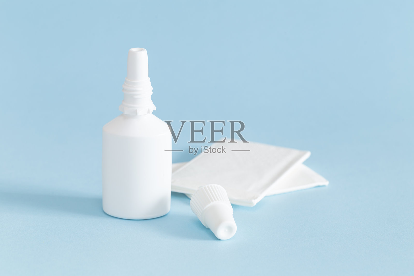 一瓶带纸巾的鼻喷雾剂。照片摄影图片