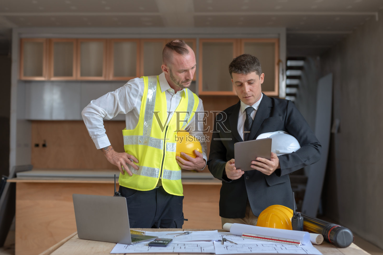 建筑师和工程师一起绘制建筑草图，并在施工现场进行讨论。照片摄影图片