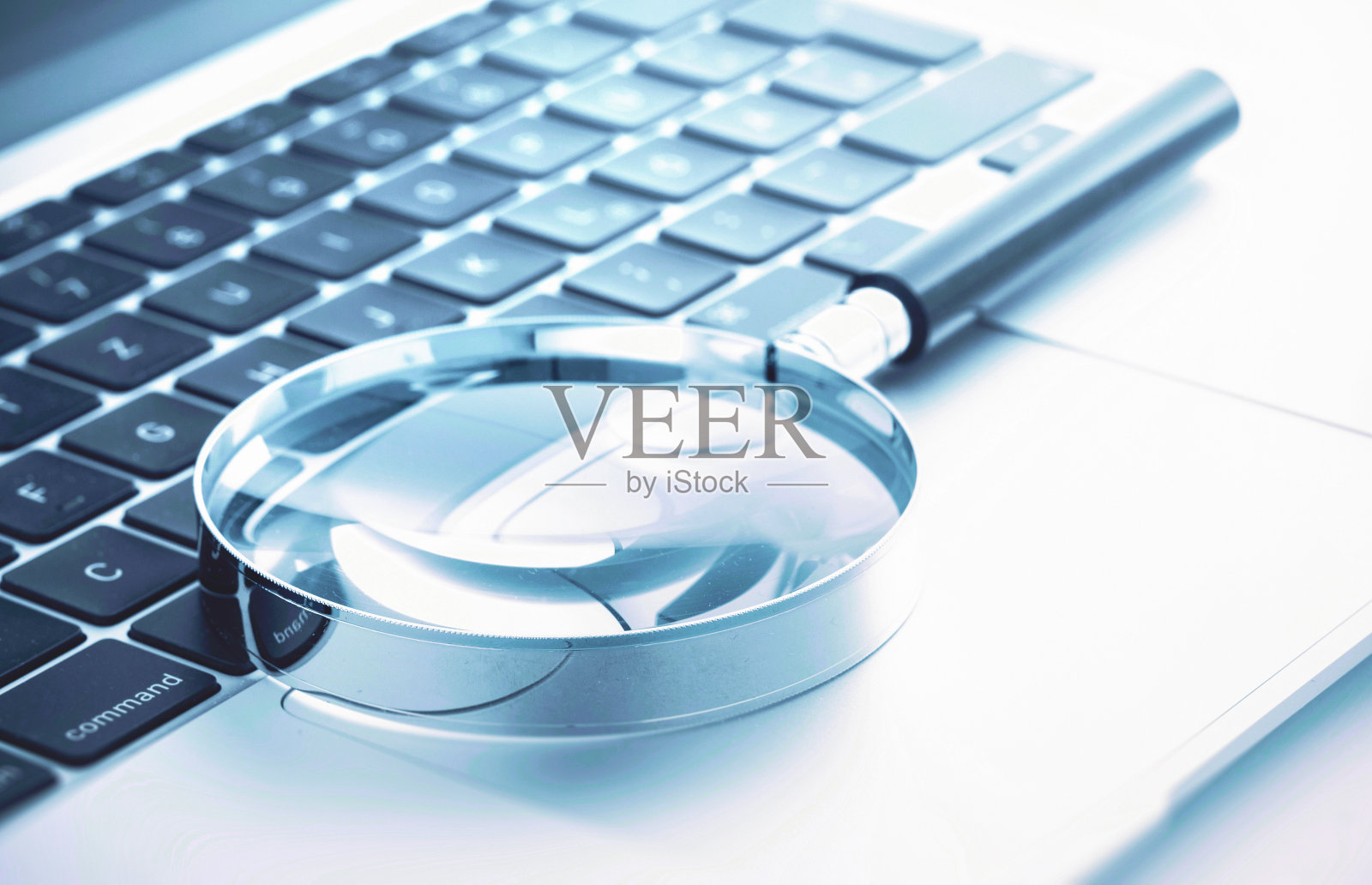 放大镜放在笔记本电脑键盘上照片摄影图片