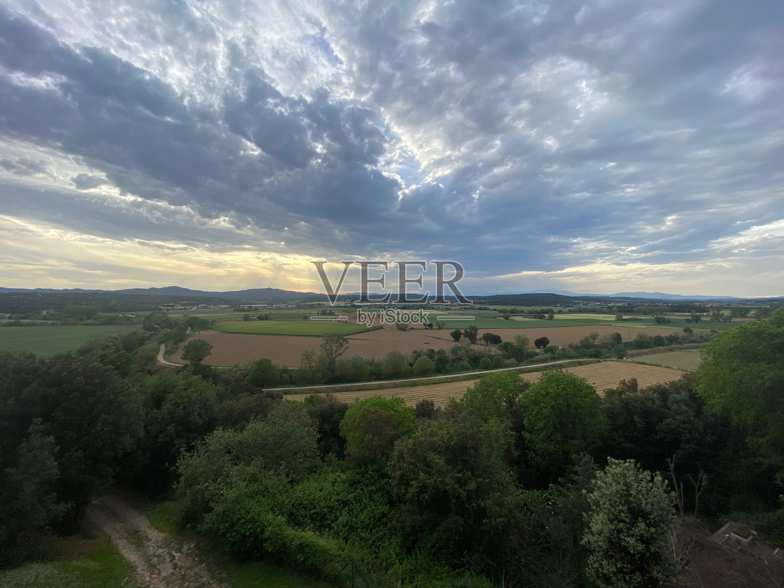 天空中的云景，阳光照耀在加泰罗尼亚赫罗纳的棕色农田景观上照片摄影图片