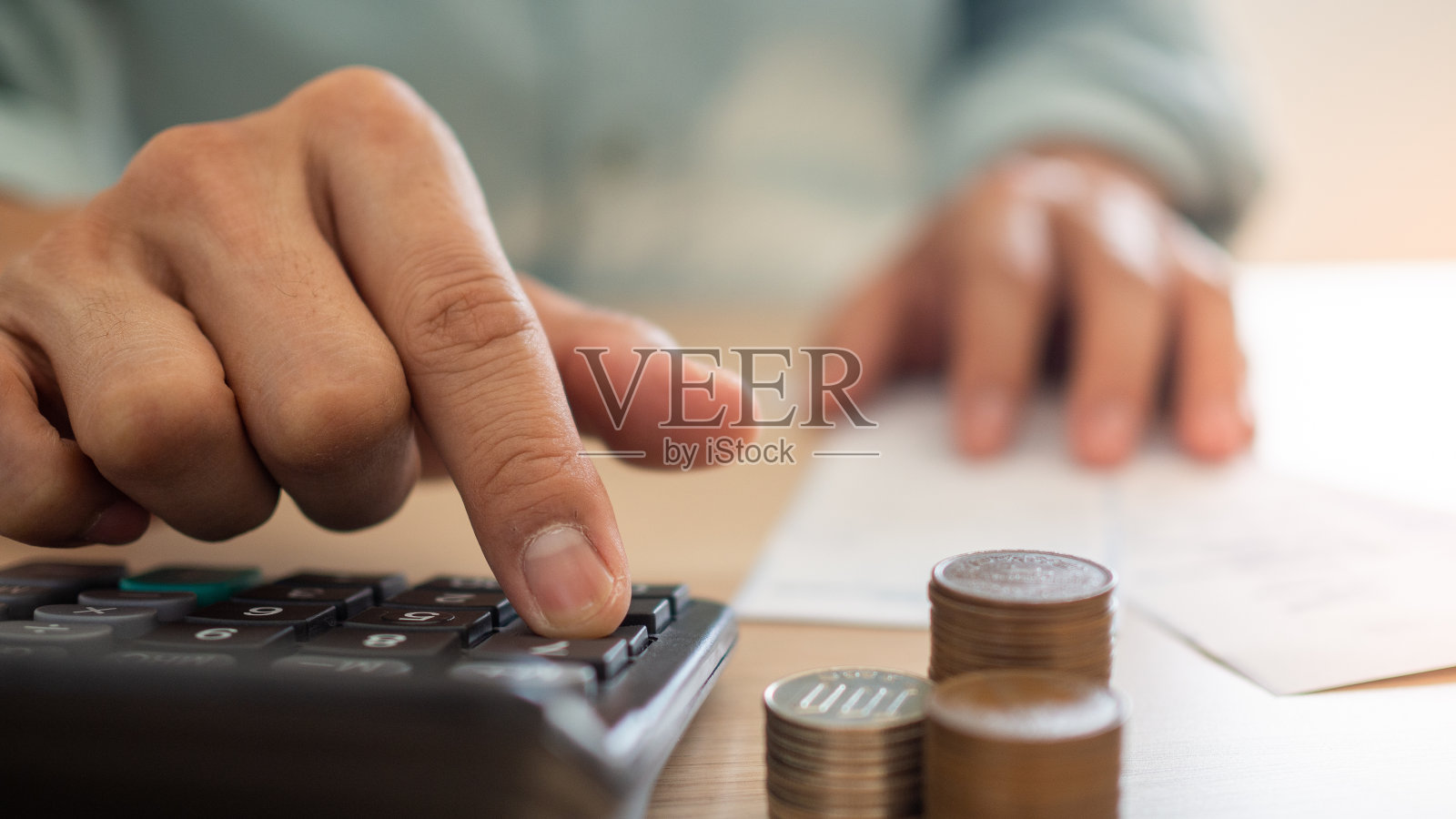 一个商人使用计算器和财务计划的特写。从各种家庭账单中计算费用照片摄影图片