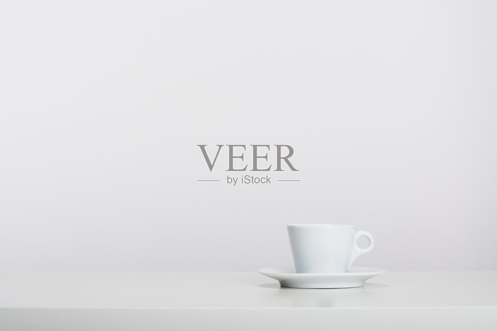 白色瓷麦浓缩咖啡杯与碟子在白色的背景，柔和的阴影照片摄影图片