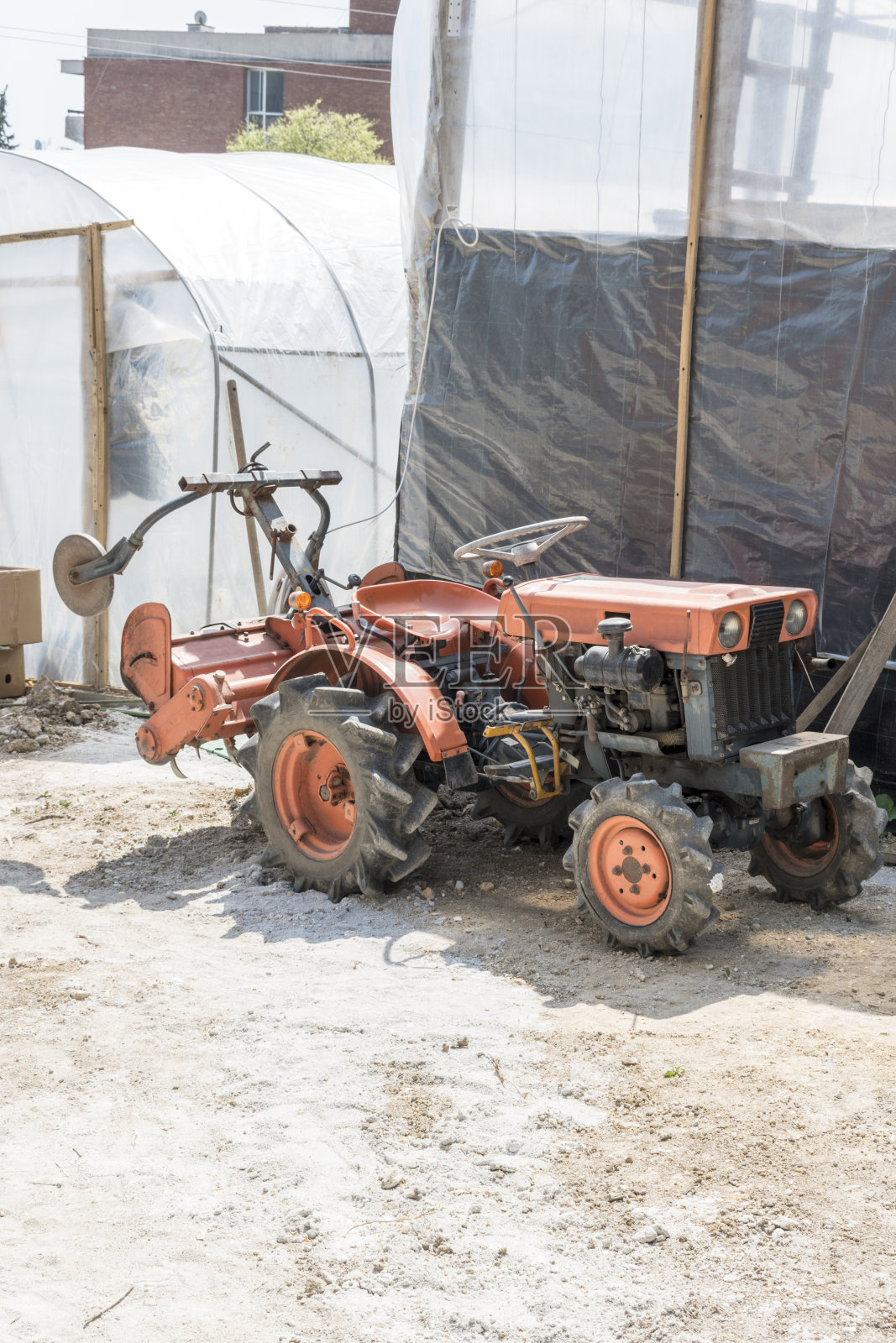 公园里准备沥青的小型挖掘机。照片摄影图片