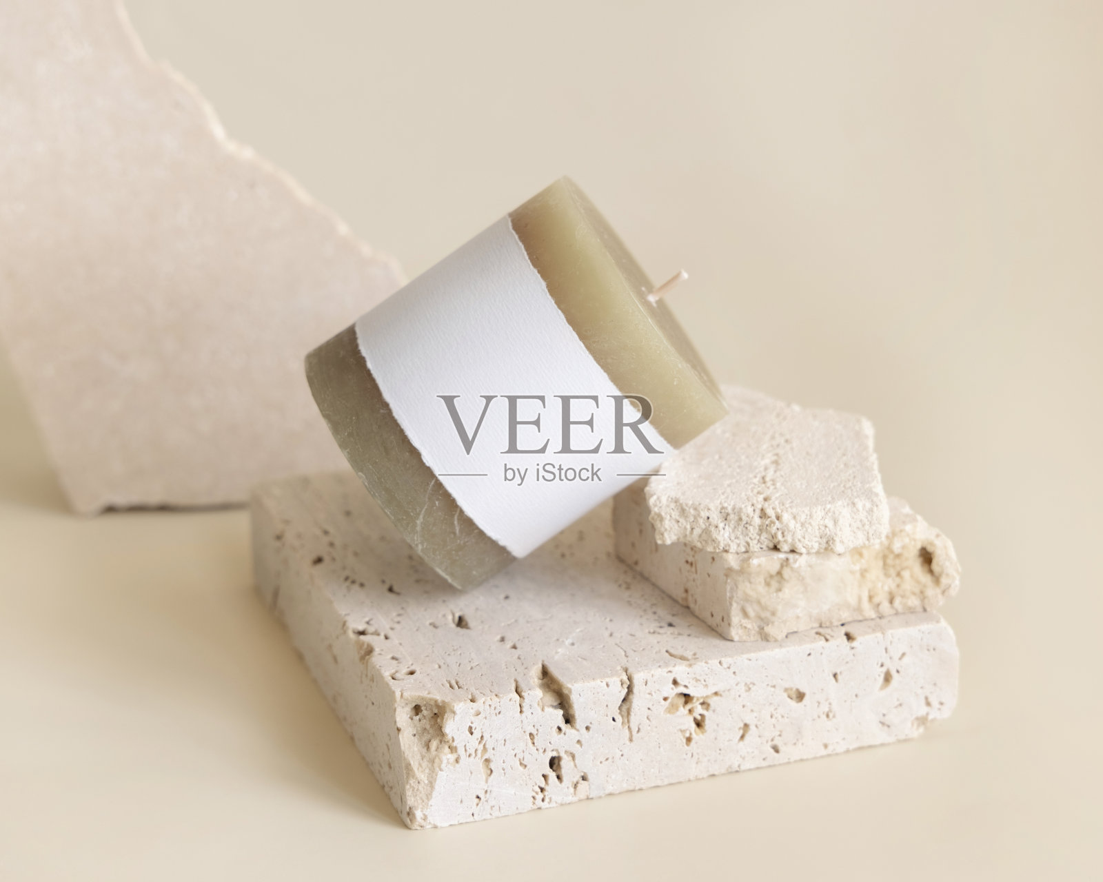 米色标签上的蜡烛，靠近奶油石灰华。包装模型照片摄影图片