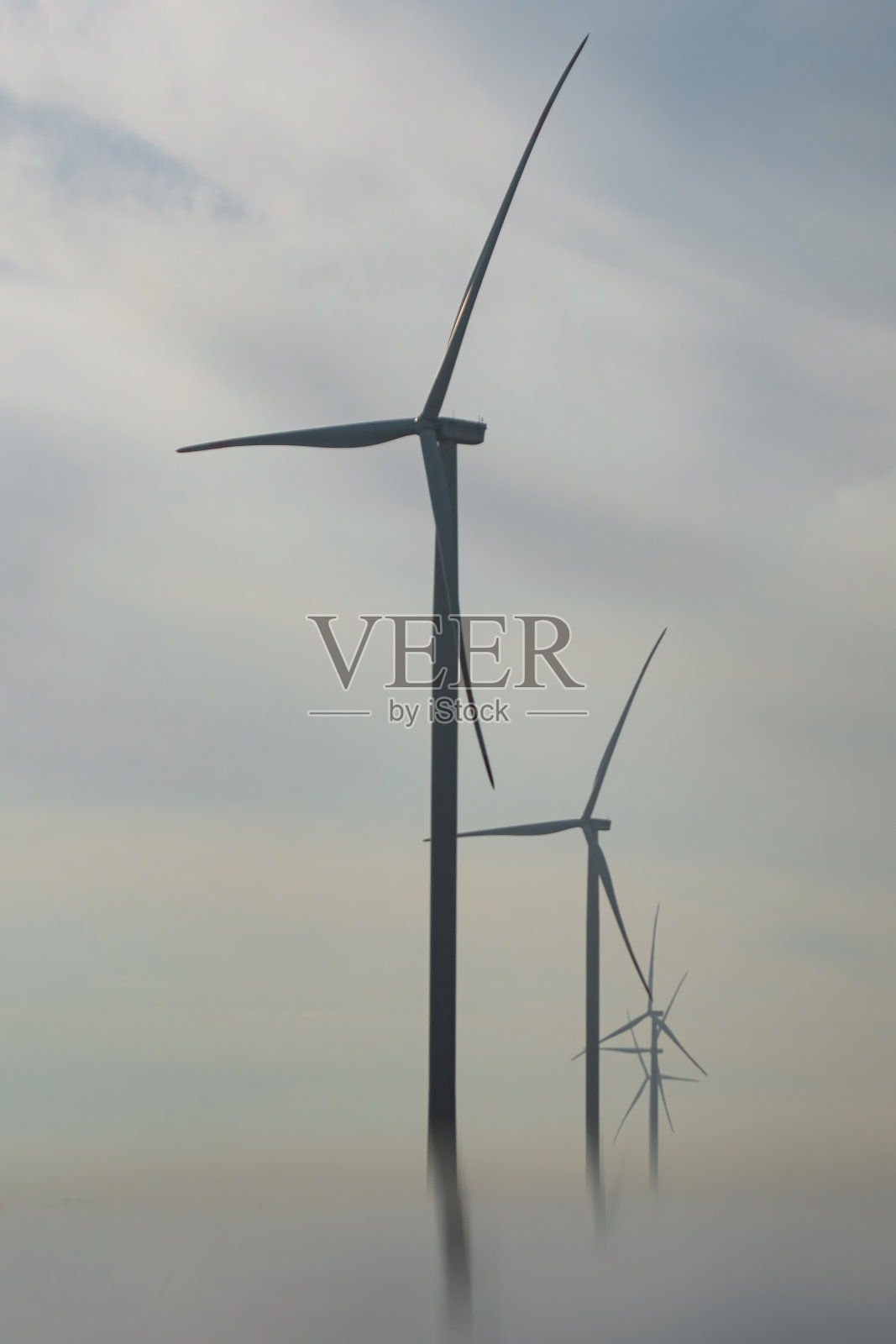 带有转子叶片的风车在雾中产生绿色能源照片摄影图片