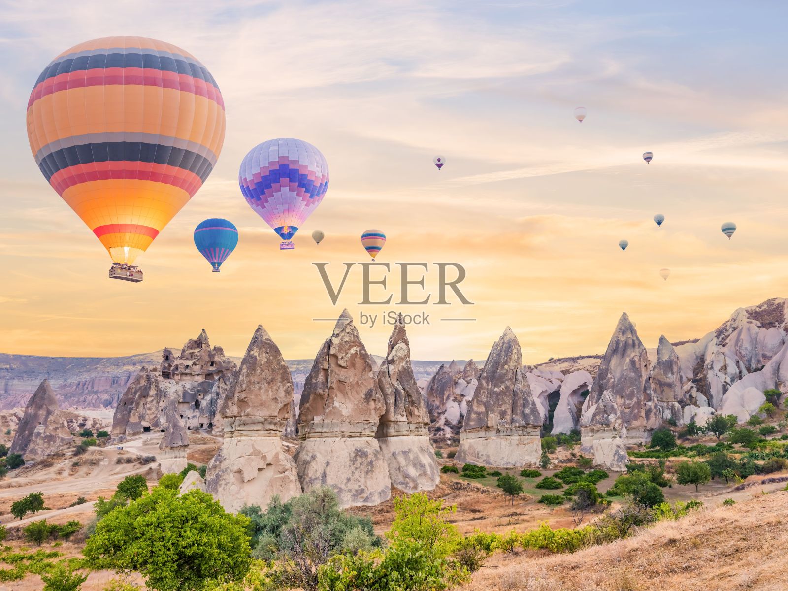 日落时分，在土耳其卡帕多西亚的戈雷姆，热气球漂浮在天空中的鸟瞰图照片摄影图片