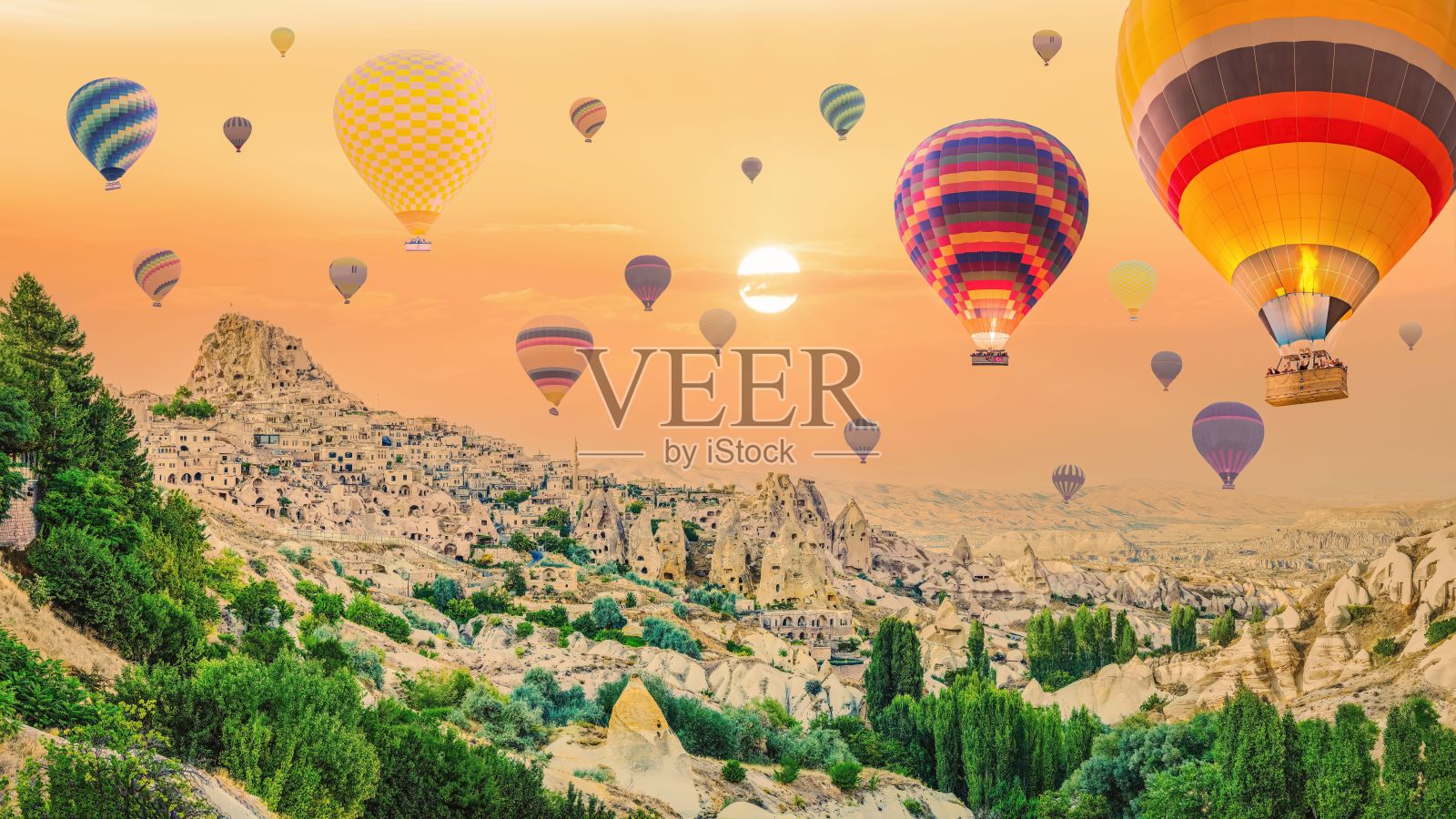 日落时分，在土耳其卡帕多西亚的戈雷姆，热气球漂浮在天空中的鸟瞰图照片摄影图片