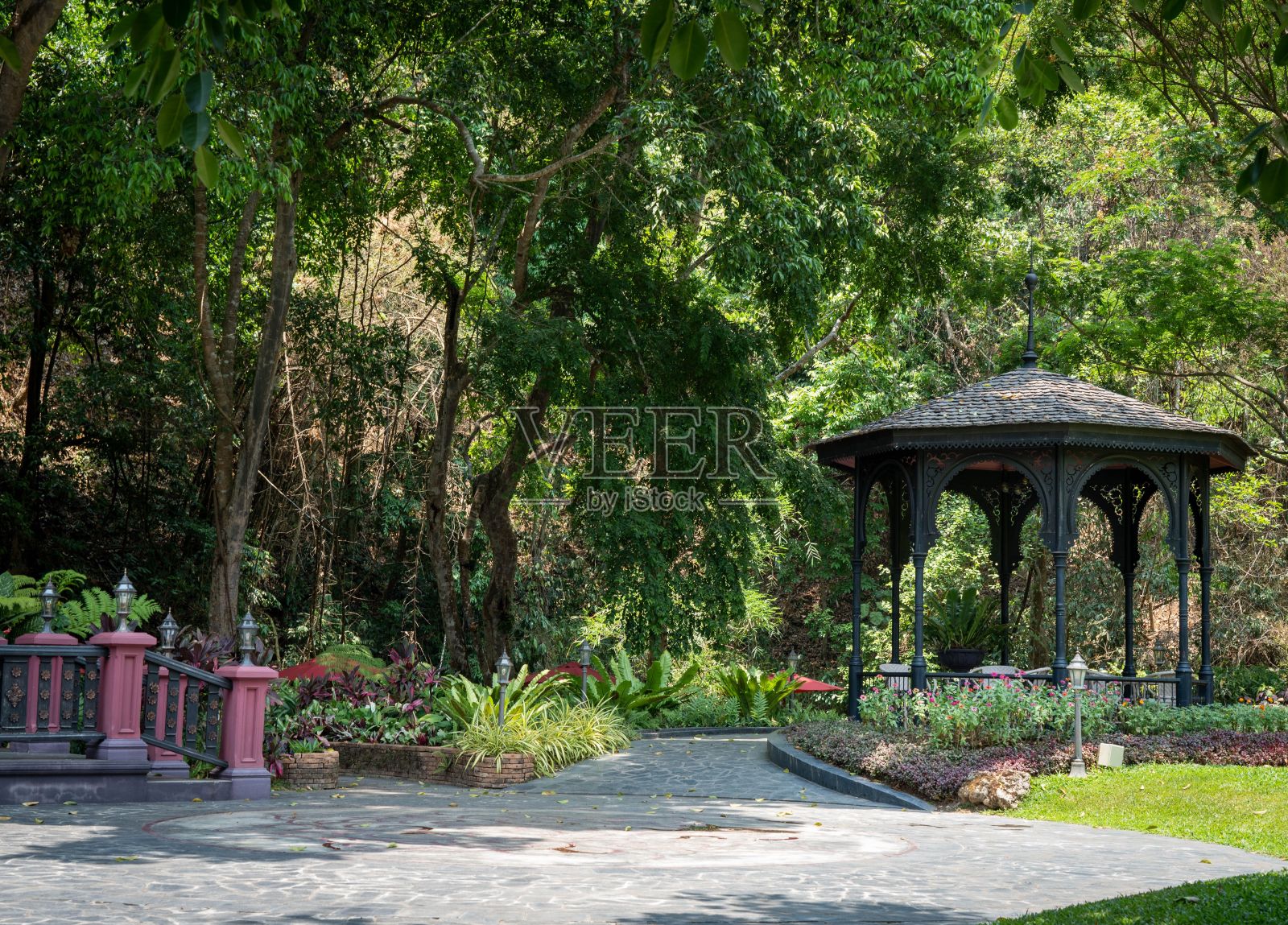 花园中的凉亭，有一条石径和郁郁葱葱的绿树照片摄影图片