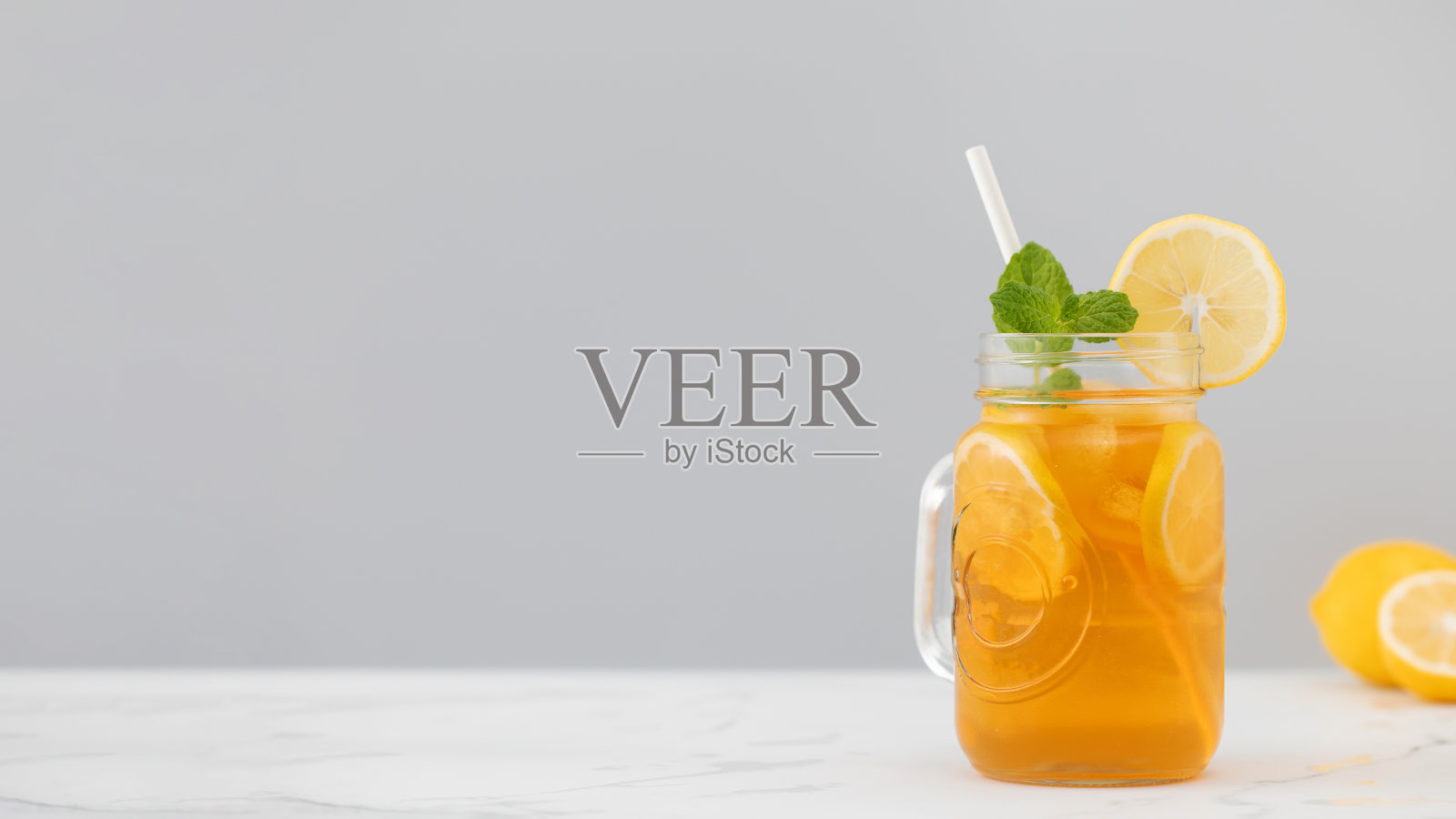 一杯冰镇茶、冰块、柠檬片和一枝薄荷，清凉的夏季饮品照片摄影图片