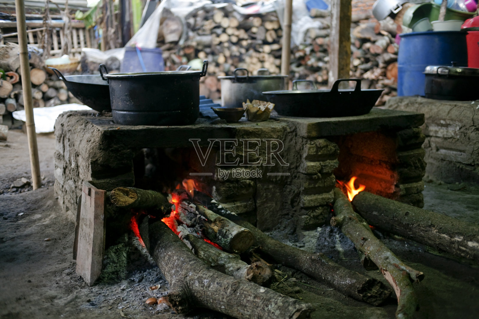 农村的厨房。印度尼西亚农村居民使用的传统炉灶，由粘土制成，以木材为燃料，在农村用干叶子和木材在土壤上烹饪食物照片摄影图片