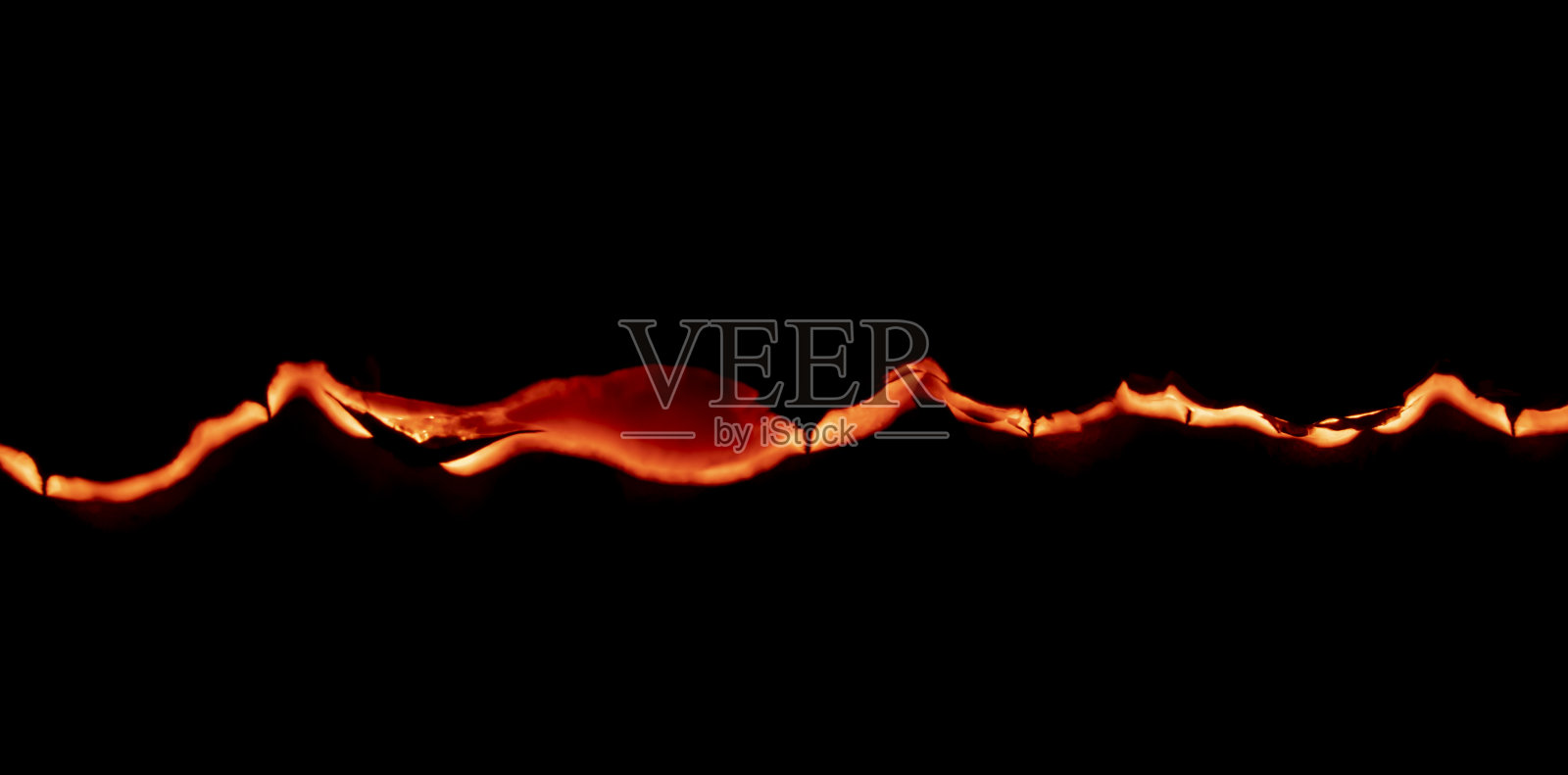 燃烧的纸，在黑色背景上发光的纸边照片摄影图片