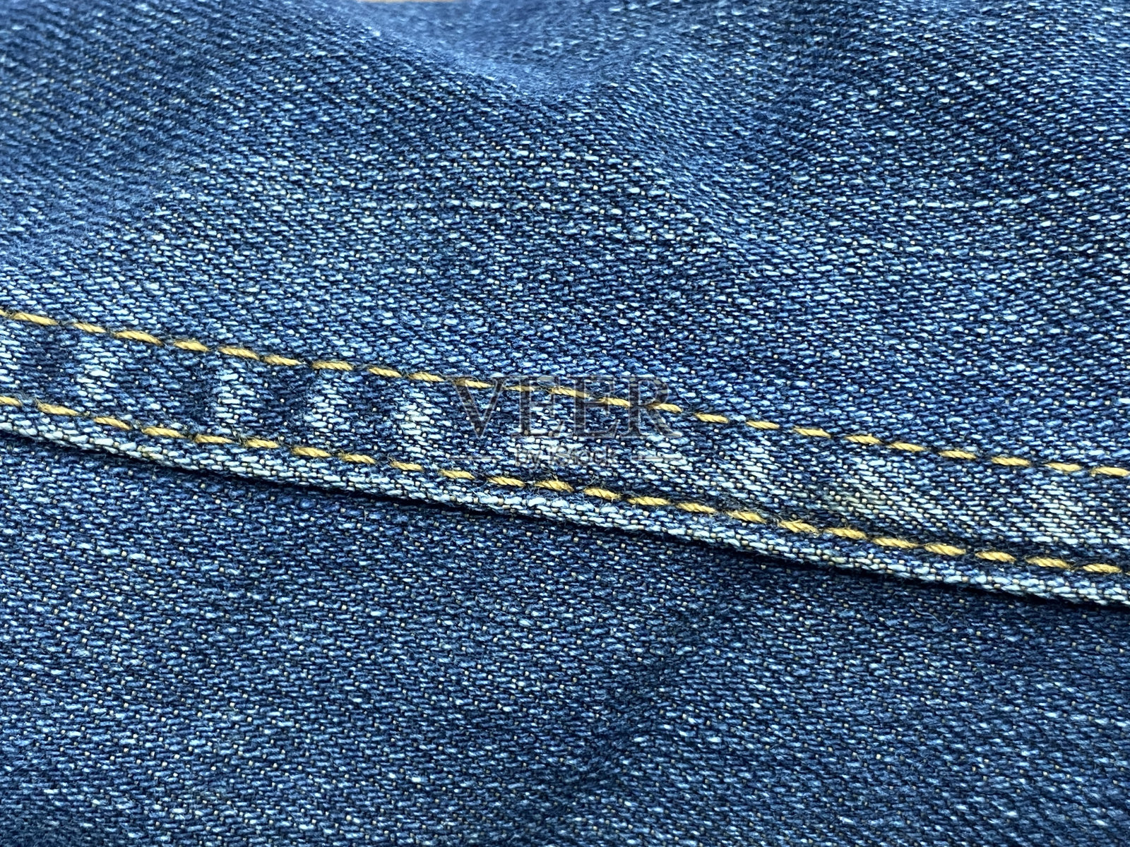 带接缝的蓝色牛仔牛仔裤的质地。照片摄影图片