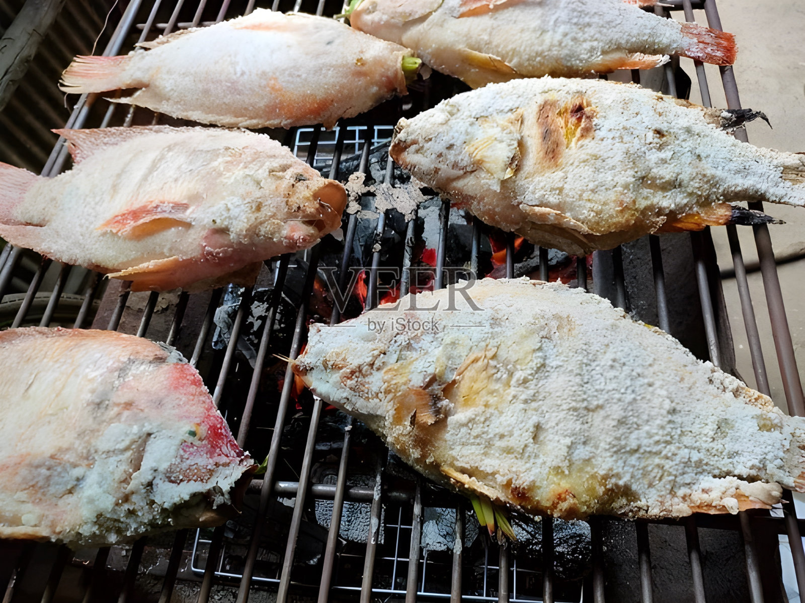 烤架上的烤罗非鱼照片摄影图片