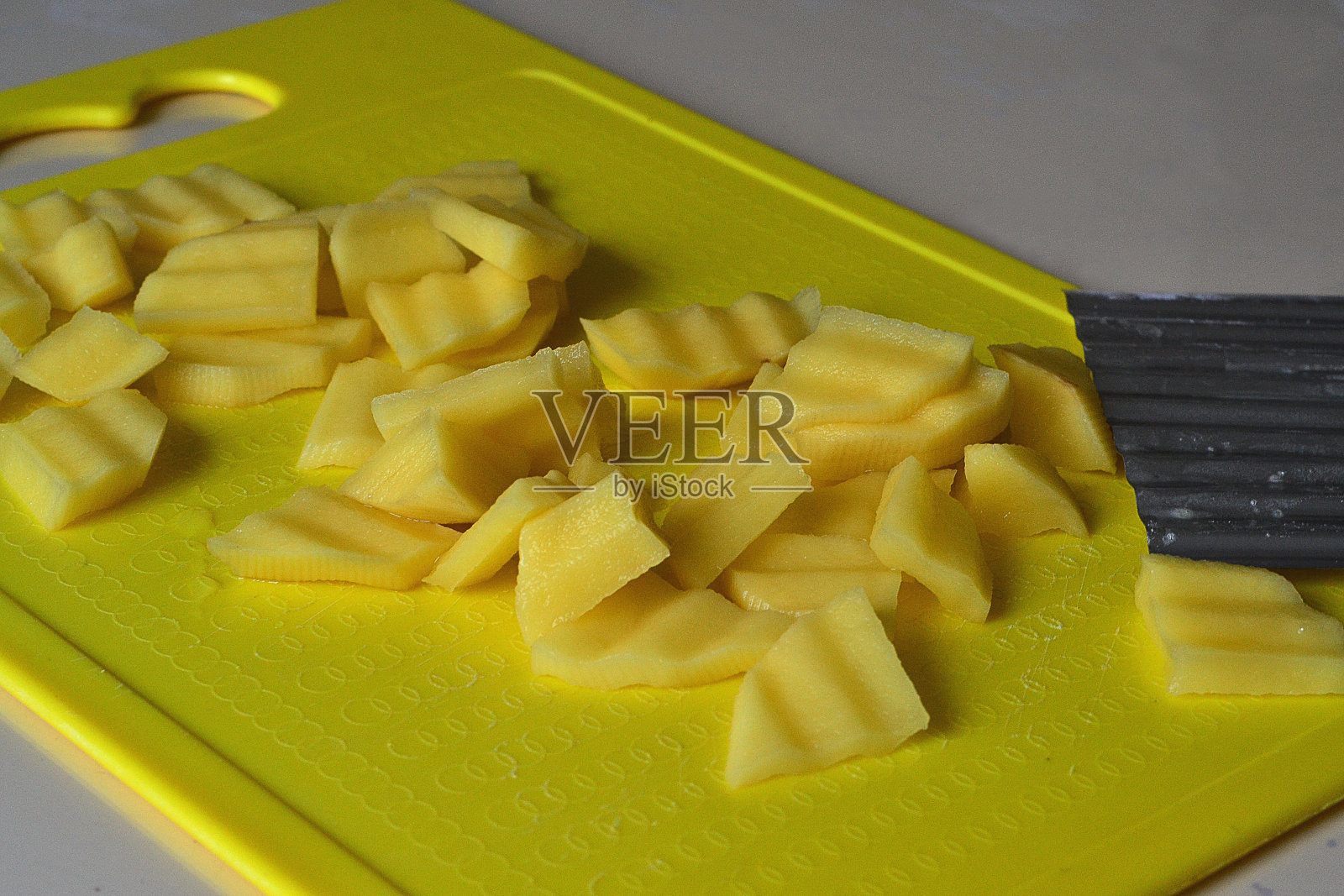 用小刀在黄板上切土豆照片摄影图片