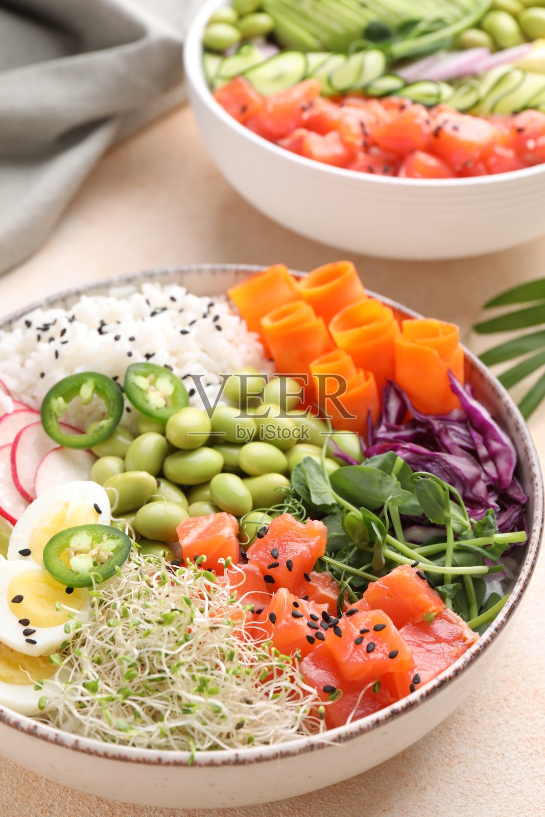 美味的poke碗与蔬菜，鱼和毛豆在浅色的桌子上，特写照片摄影图片