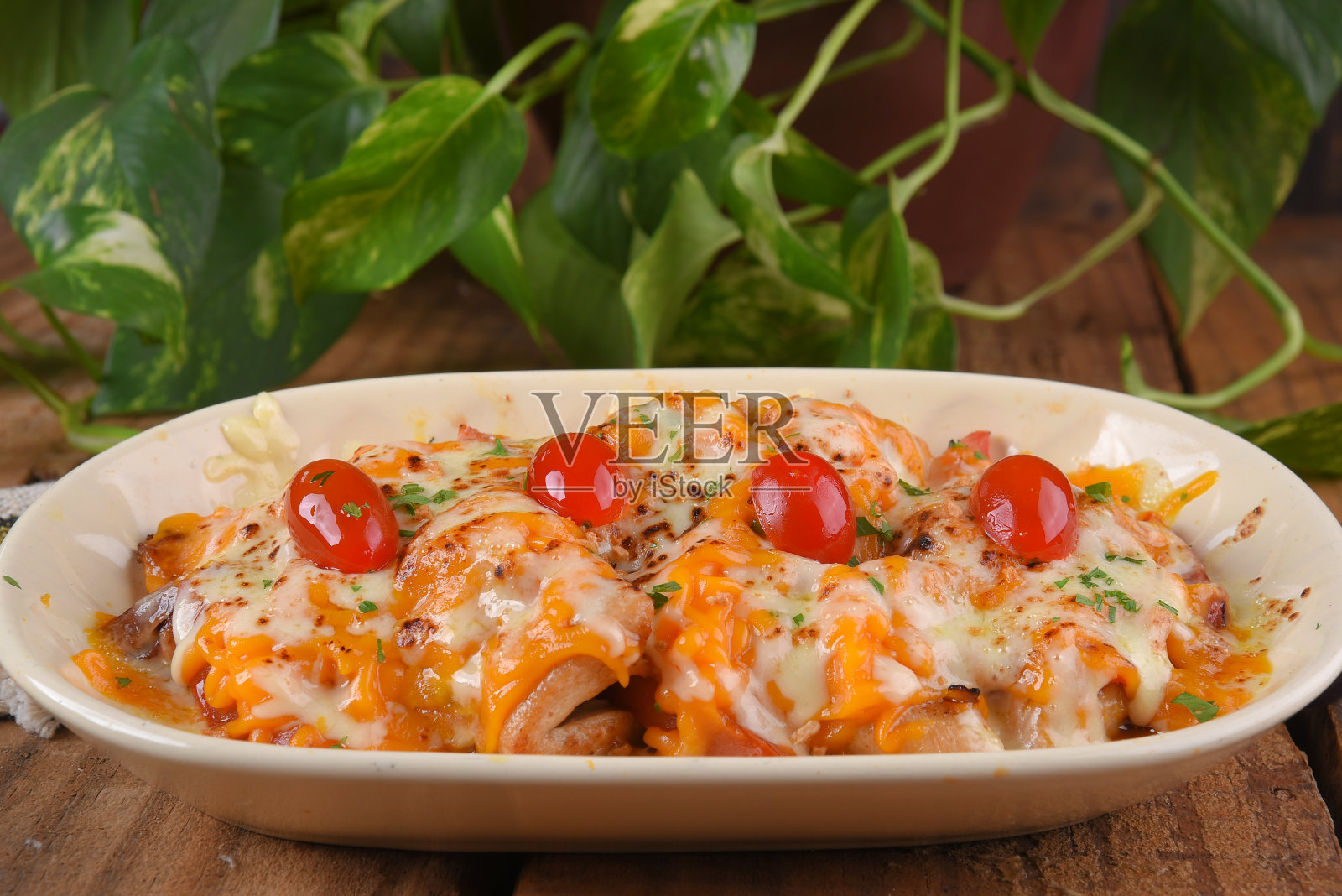 炸鸡配马苏里拉干酪、切达干酪、圣女果和焦糖洋葱，木桌美味照片摄影图片