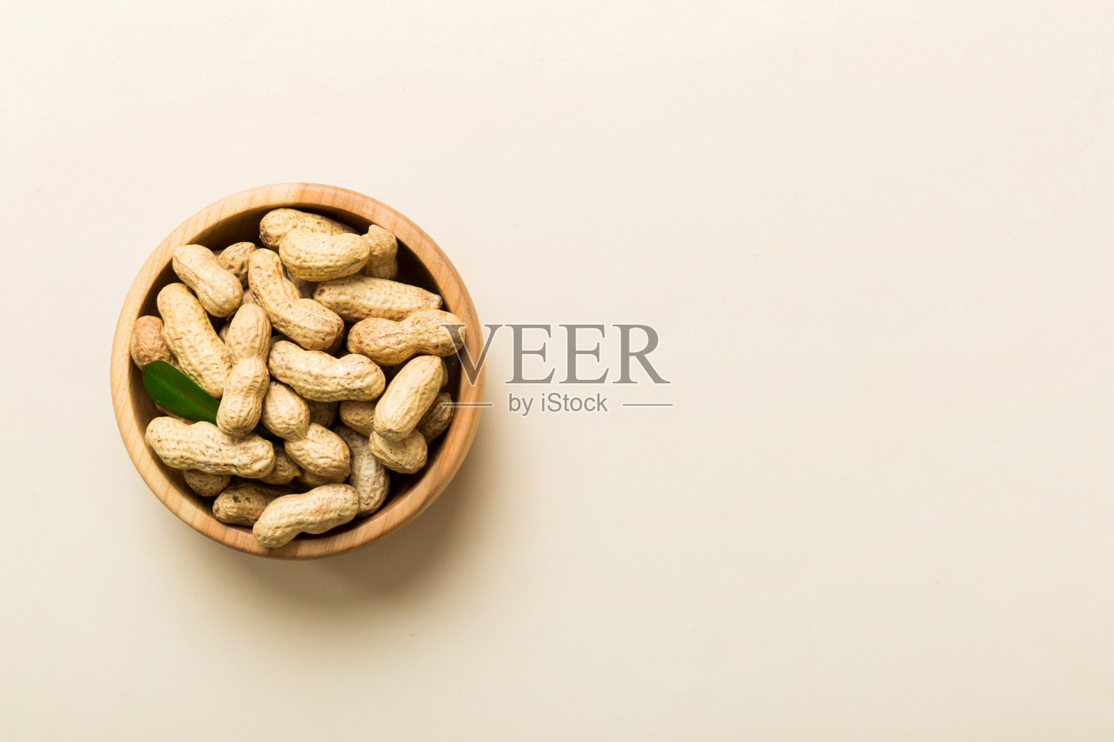 新鲜健康的花生在碗在彩色的桌子背景。健康饮食bertholletia概念。超级食物照片摄影图片