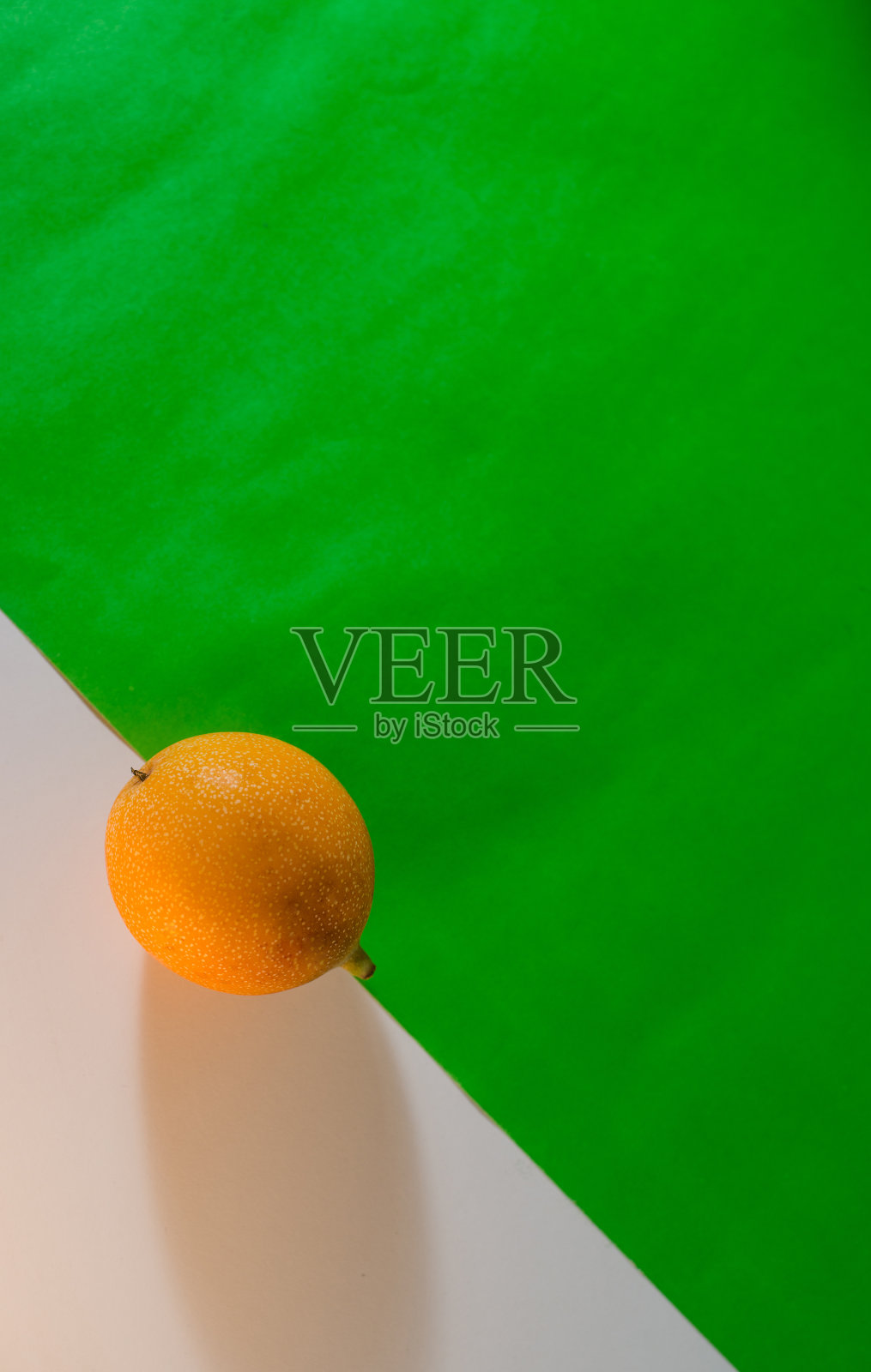 在白色和绿色背景上的石榴静物，在极简主义背景上的热带石榴特写照片摄影图片