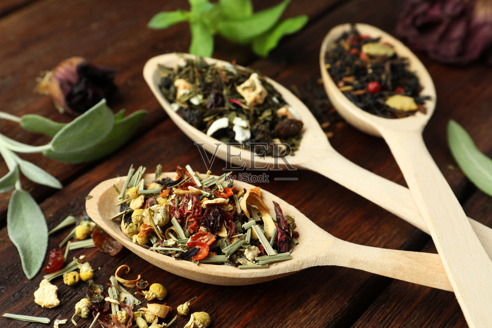 木桌上的勺子和干凉茶叶，特写照片摄影图片