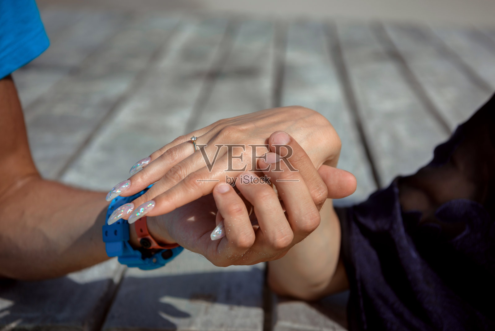 男人和女人，新婚夫妇手牵着手，背景模糊。照片摄影图片