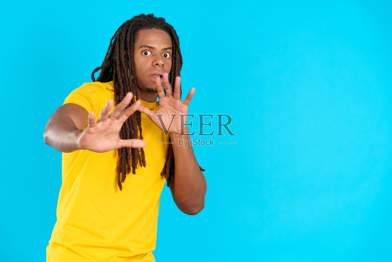 一个留着脏辫的拉丁男人，恐惧地用手比划着照片摄影图片