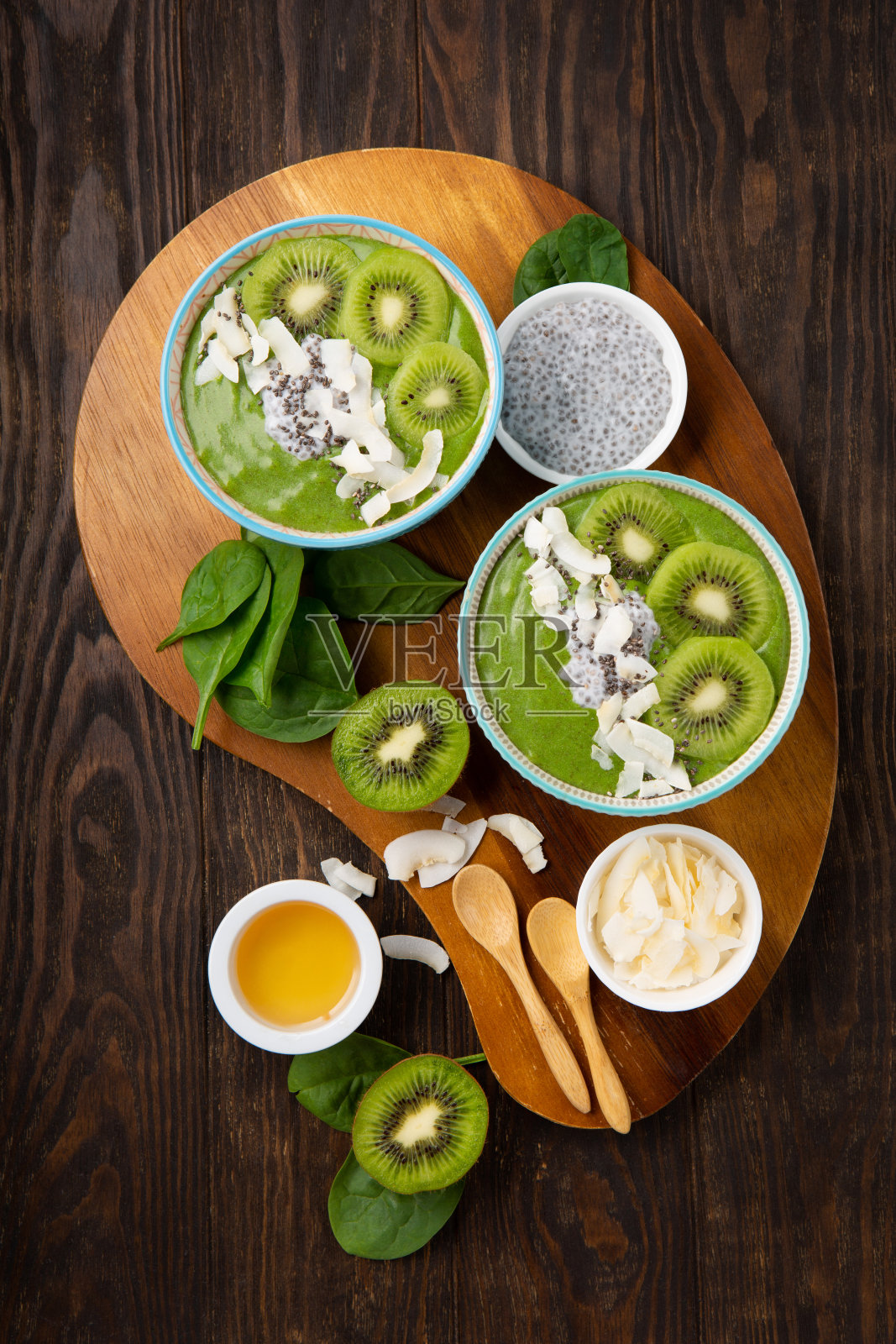 绿色奶昔碗与菠菜，香蕉，奇亚籽在棕色背景照片摄影图片