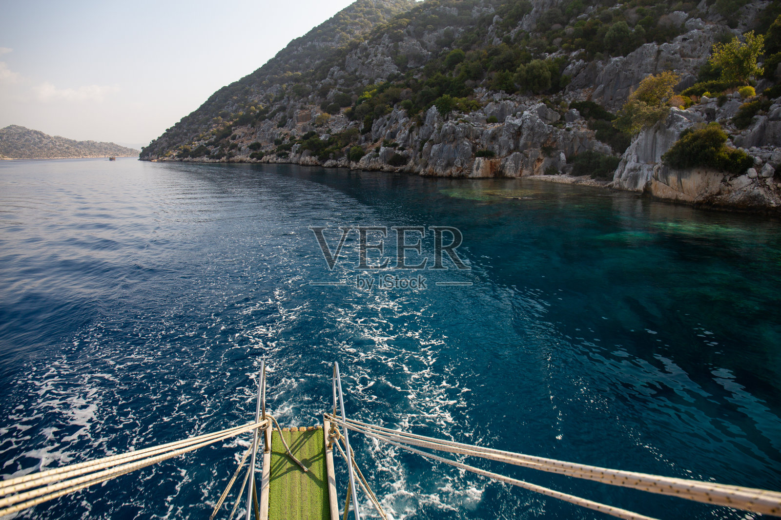 机动船。从船上看。俯瞰地中海的群山。鸟瞰图，海浪冲击着海滩上的岩石，海水呈绿松石色。照片摄影图片