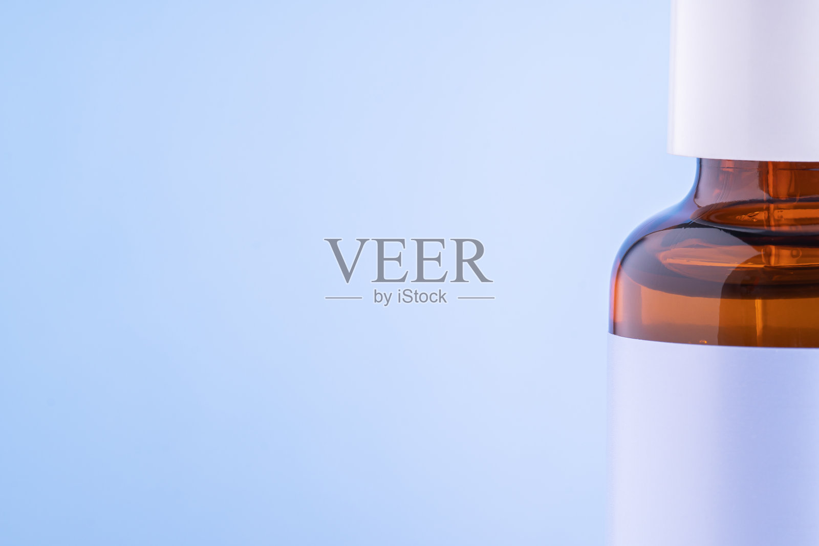 血清瓶接近蓝色背景。化妆品的背景。水疗中心的概念。照片摄影图片