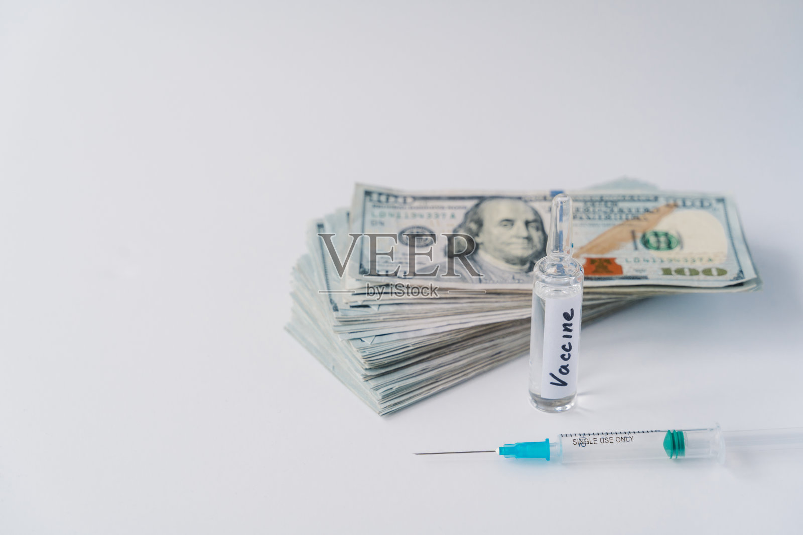 疾病、医疗、收费要求和科学观念。接种疫苗需要付费。儿童或成人用注射器和小瓶装液体疫苗。附近有一堆钱。冠状病毒预防照片摄影图片