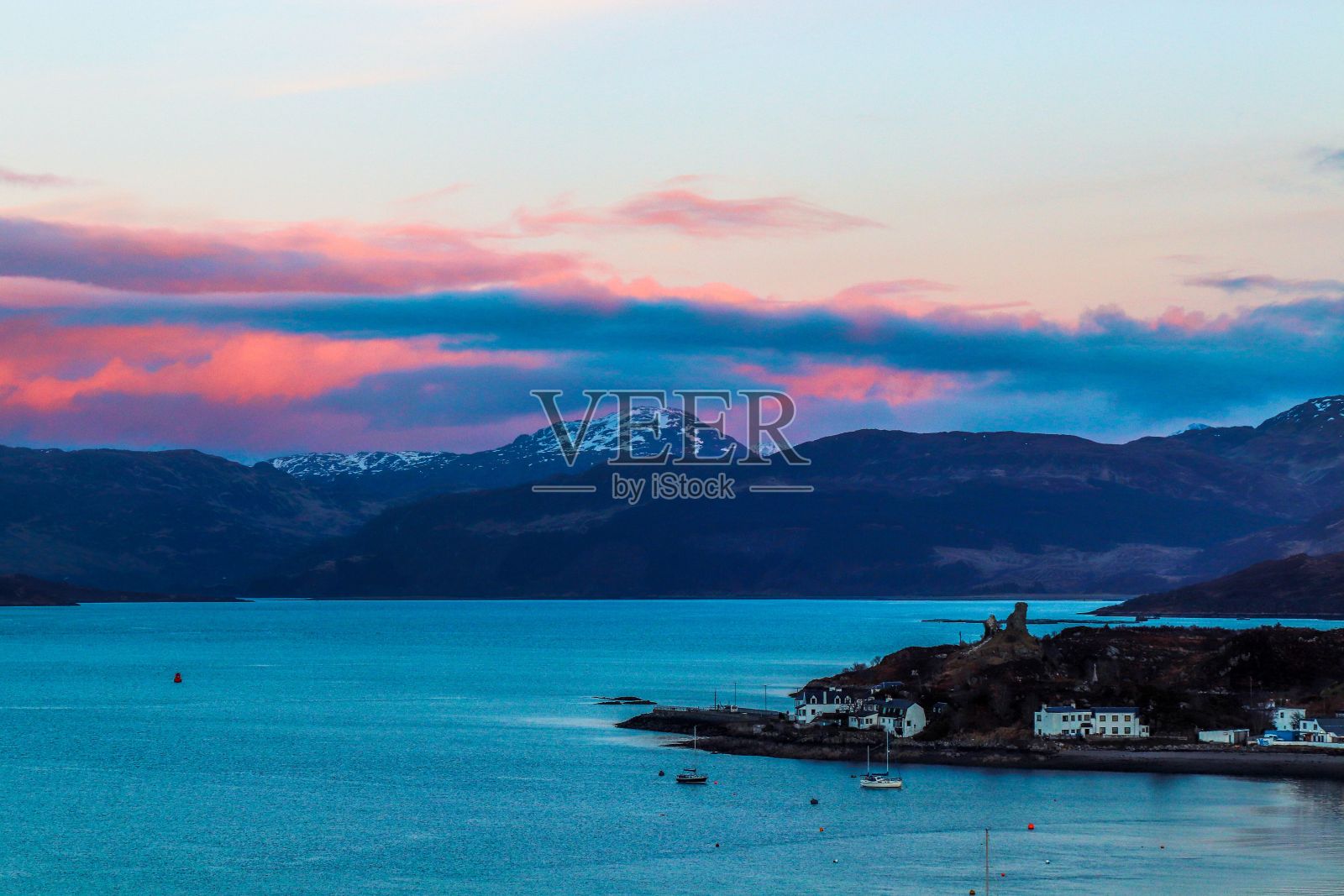 宁静的湖泊坐落在雄伟的山脉之间，日落在英国苏格兰的洛查尔什凯尔照片摄影图片