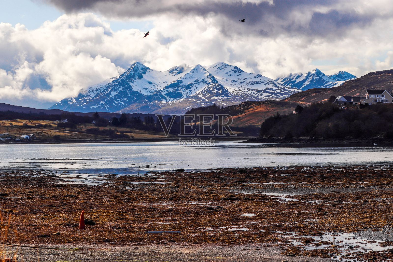 英国苏格兰斯凯岛宁静的湖泊，周围环绕着雄伟的雪山照片摄影图片