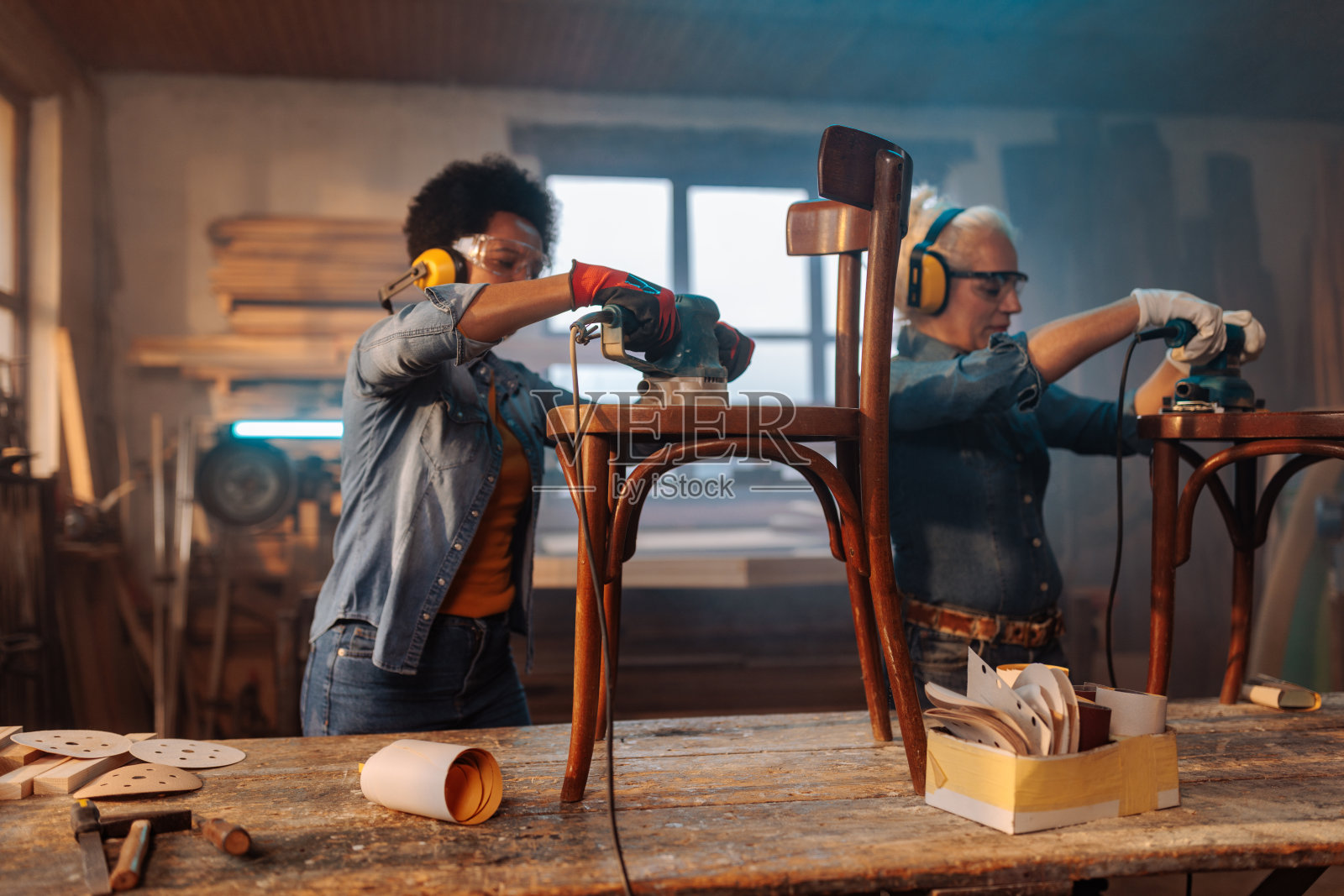 女工在车间打磨椅子。照片摄影图片