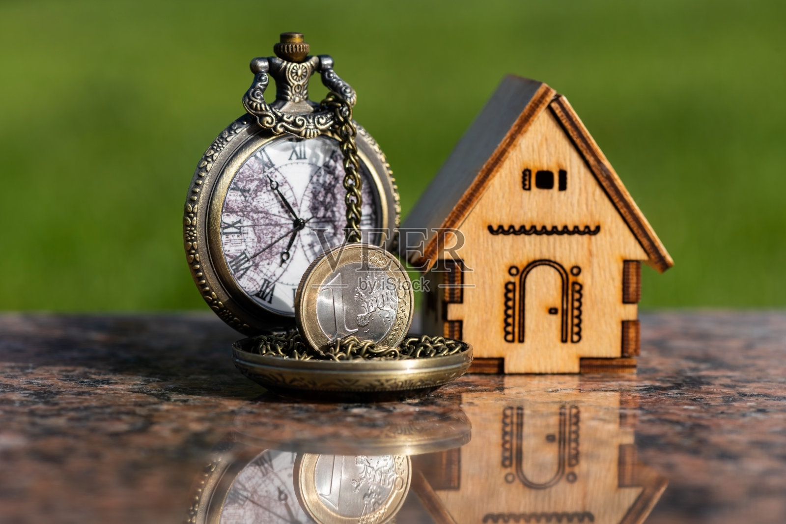 1欧元硬币，迷你木屋和古董怀表照片摄影图片