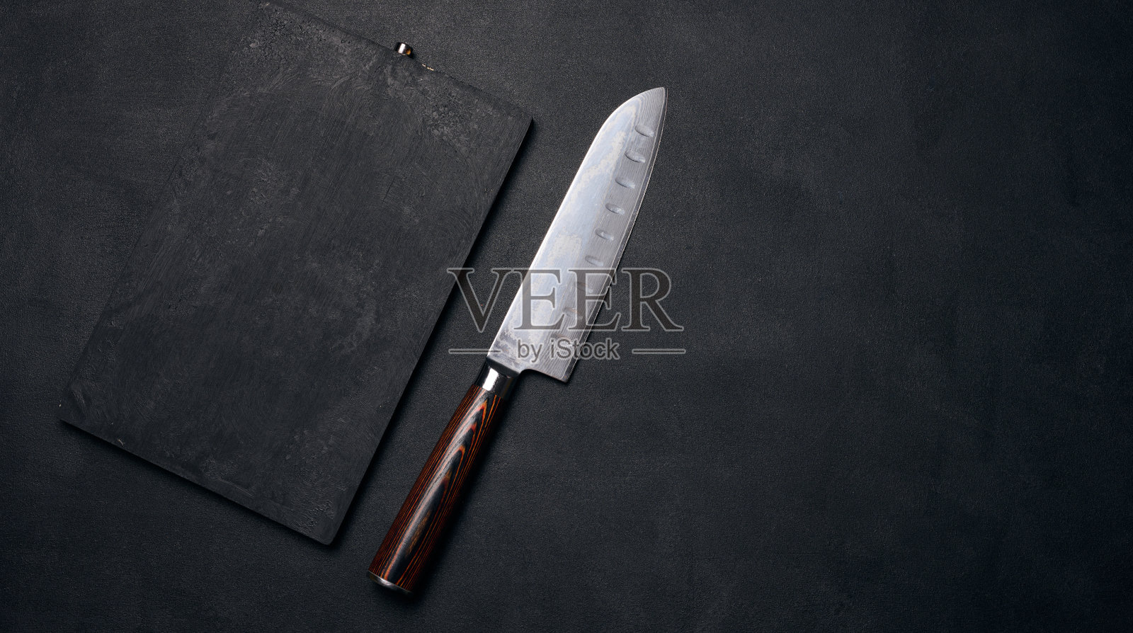 黑色的凳子上放着空的黑色木制砧板和菜刀，俯视图照片摄影图片