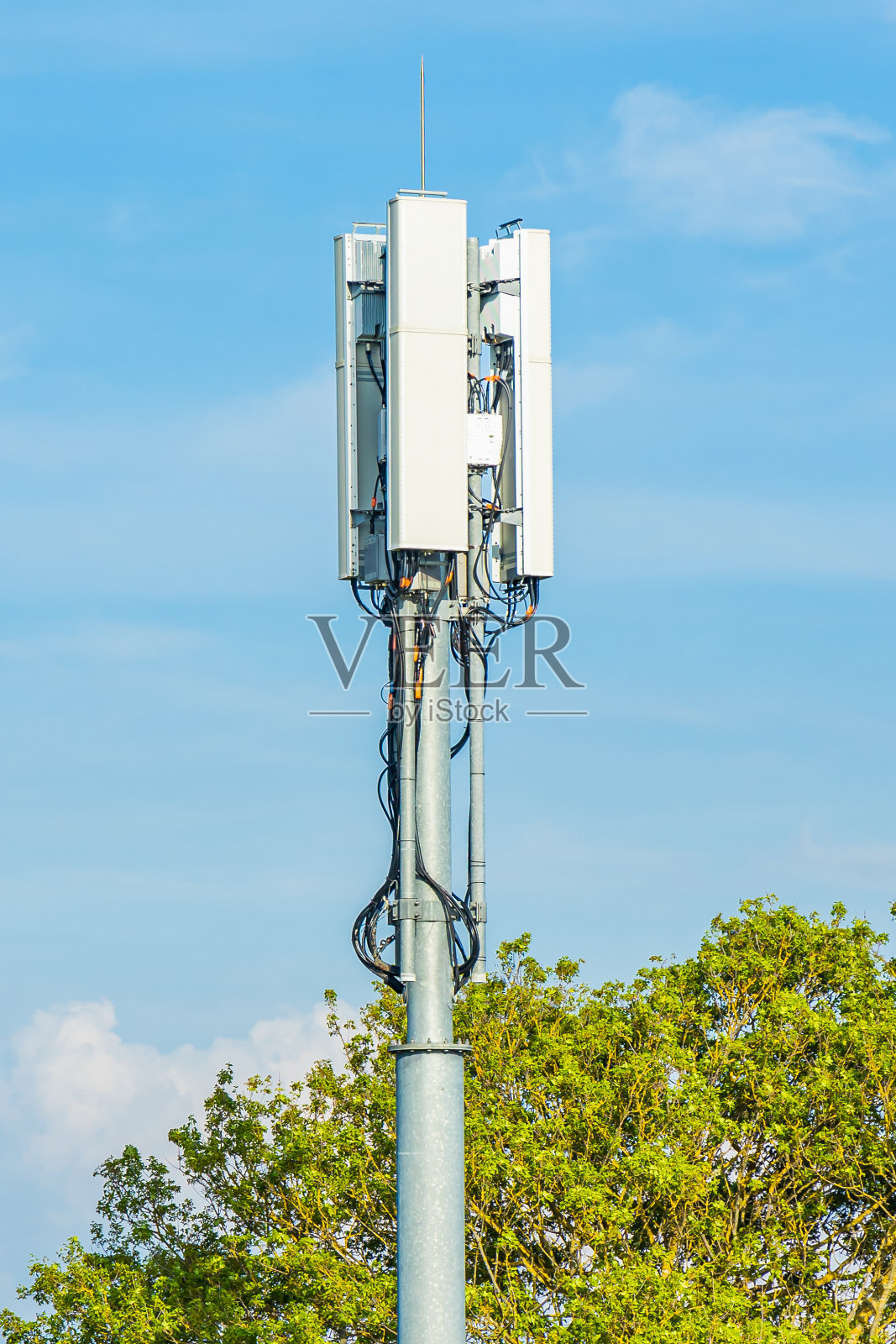 智能蜂窝网络5G天线安装在建筑物顶部的电信桅杆上照片摄影图片