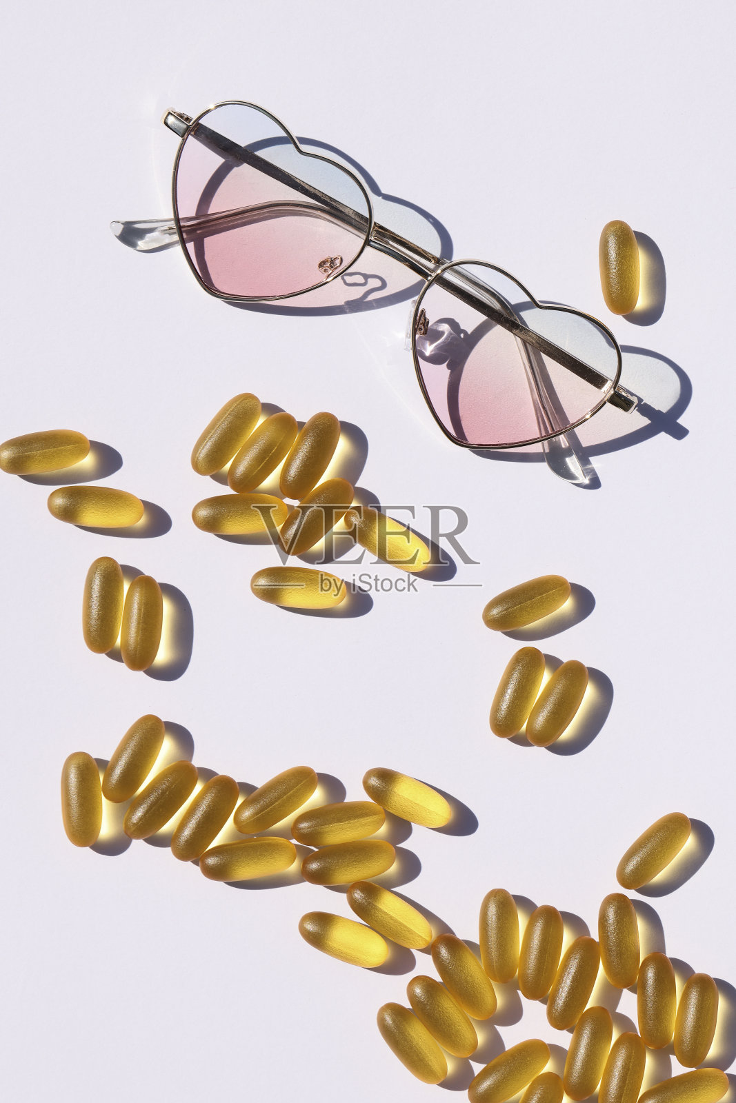防晒丸和防晒补充剂，保健理念。夏天的风格。黄色药丸和白色背景的太阳镜。本空间照片摄影图片