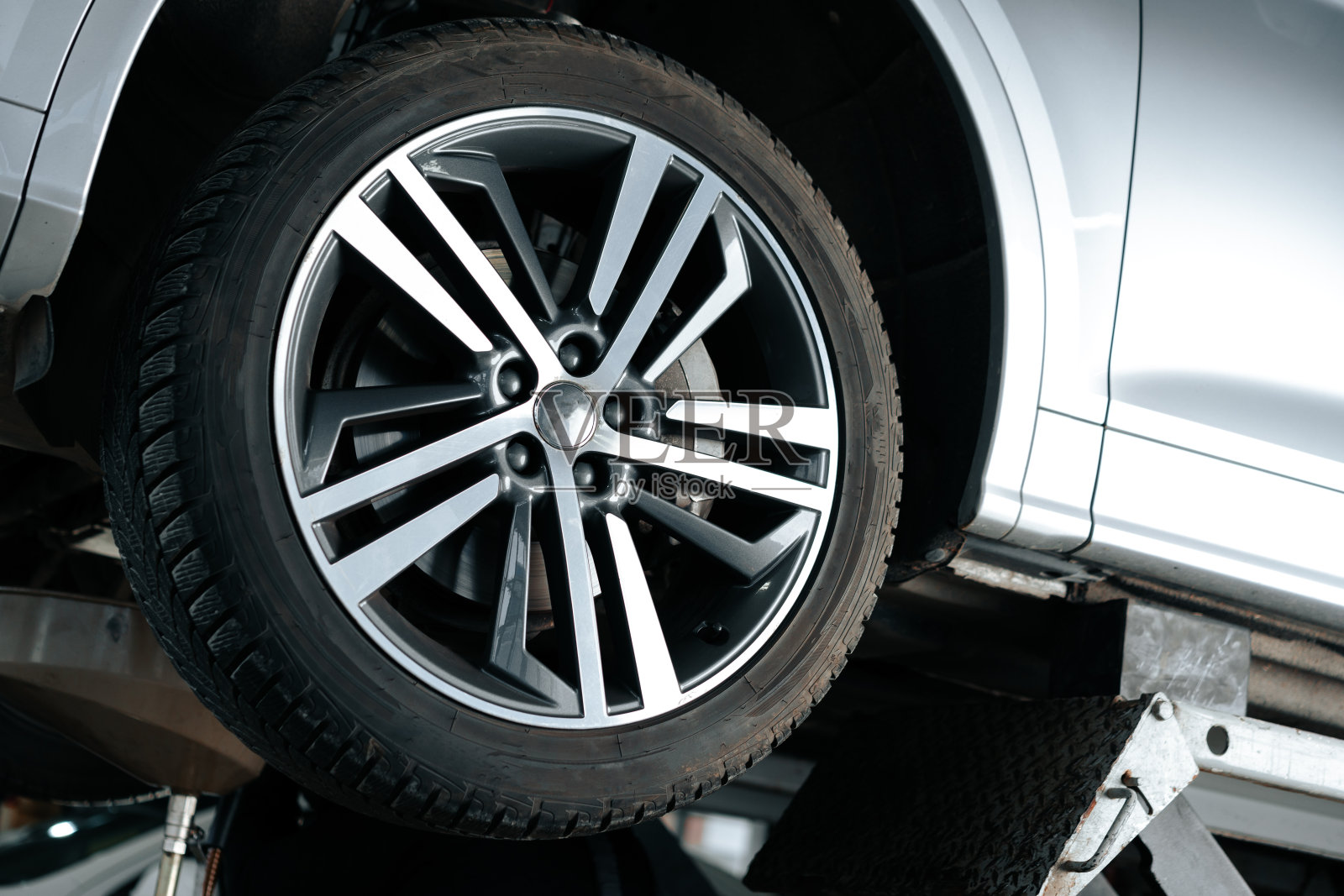 维修车间里升降机上的汽车，聚焦车轮照片摄影图片