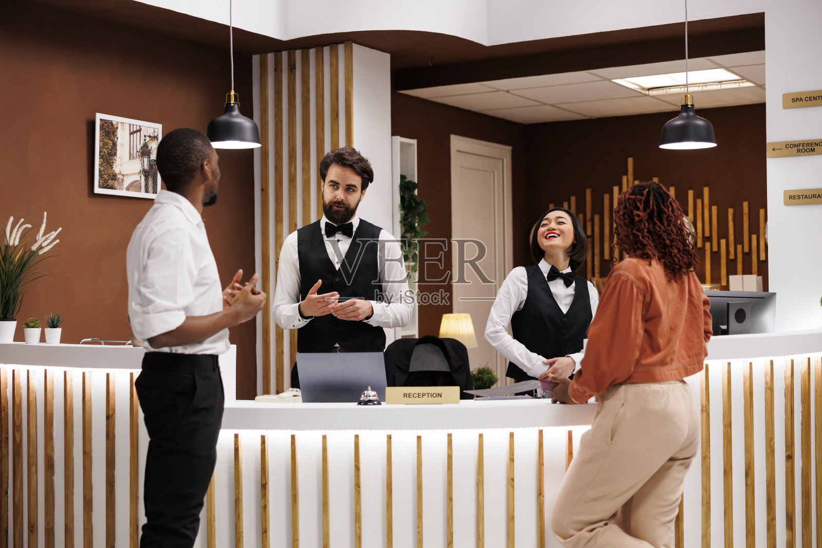 不同的工作人员帮助酒店客人照片摄影图片